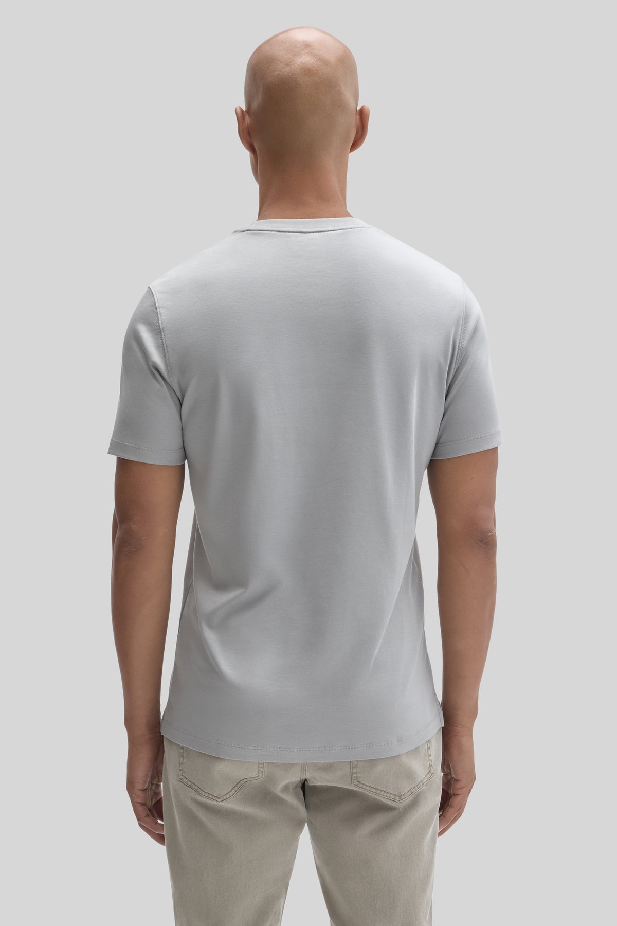 Man wearing light gray short-sleeve t-shirt with crew neckline, shown from behind.