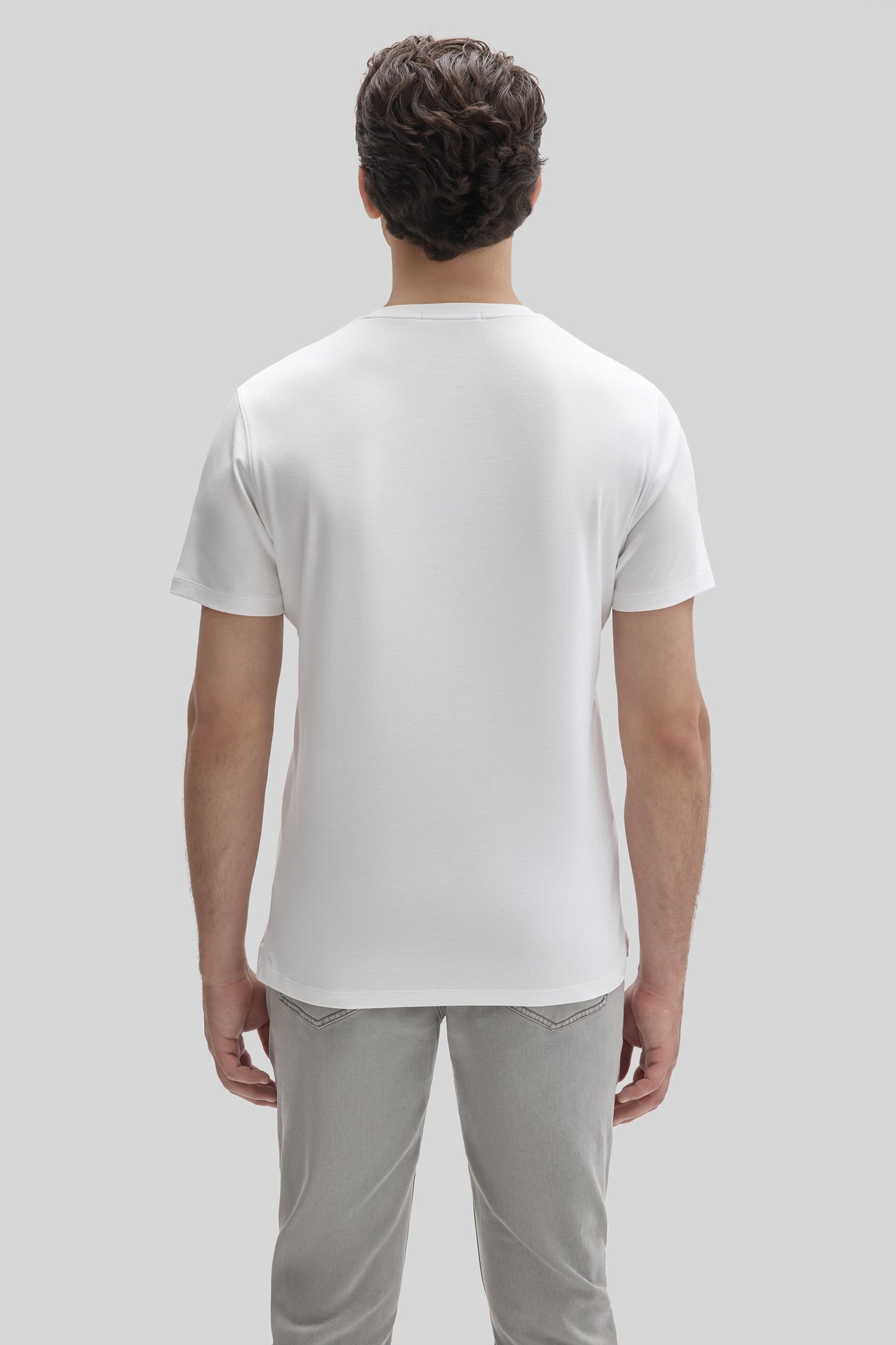 Man wearing white short-sleeve t-shirt, back view.