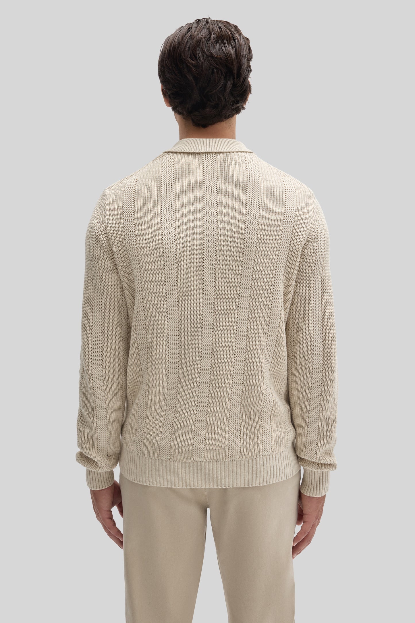 Cream-colored knit polo sweater with ribbed texture and collar, shown on model from back view.