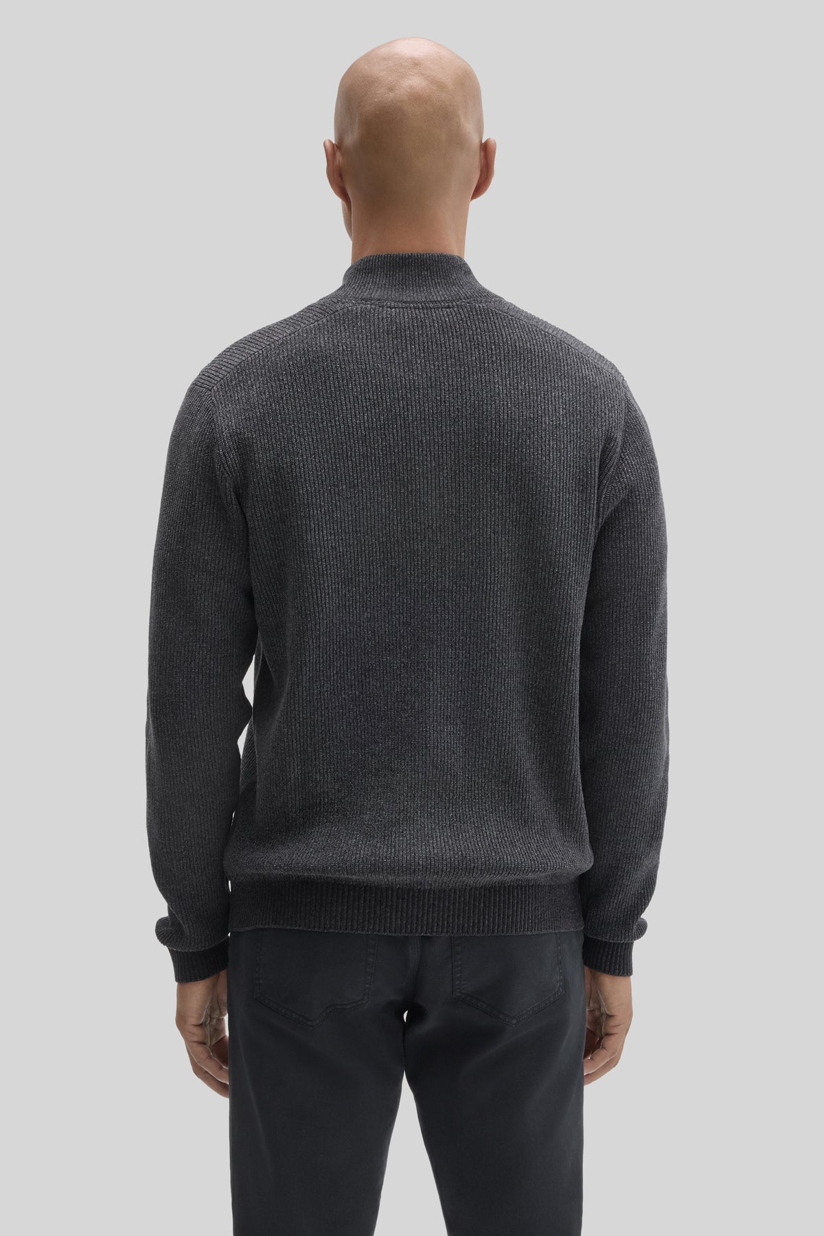 Charcoal gray ribbed mock neck sweater worn with black pants, shown from back view.