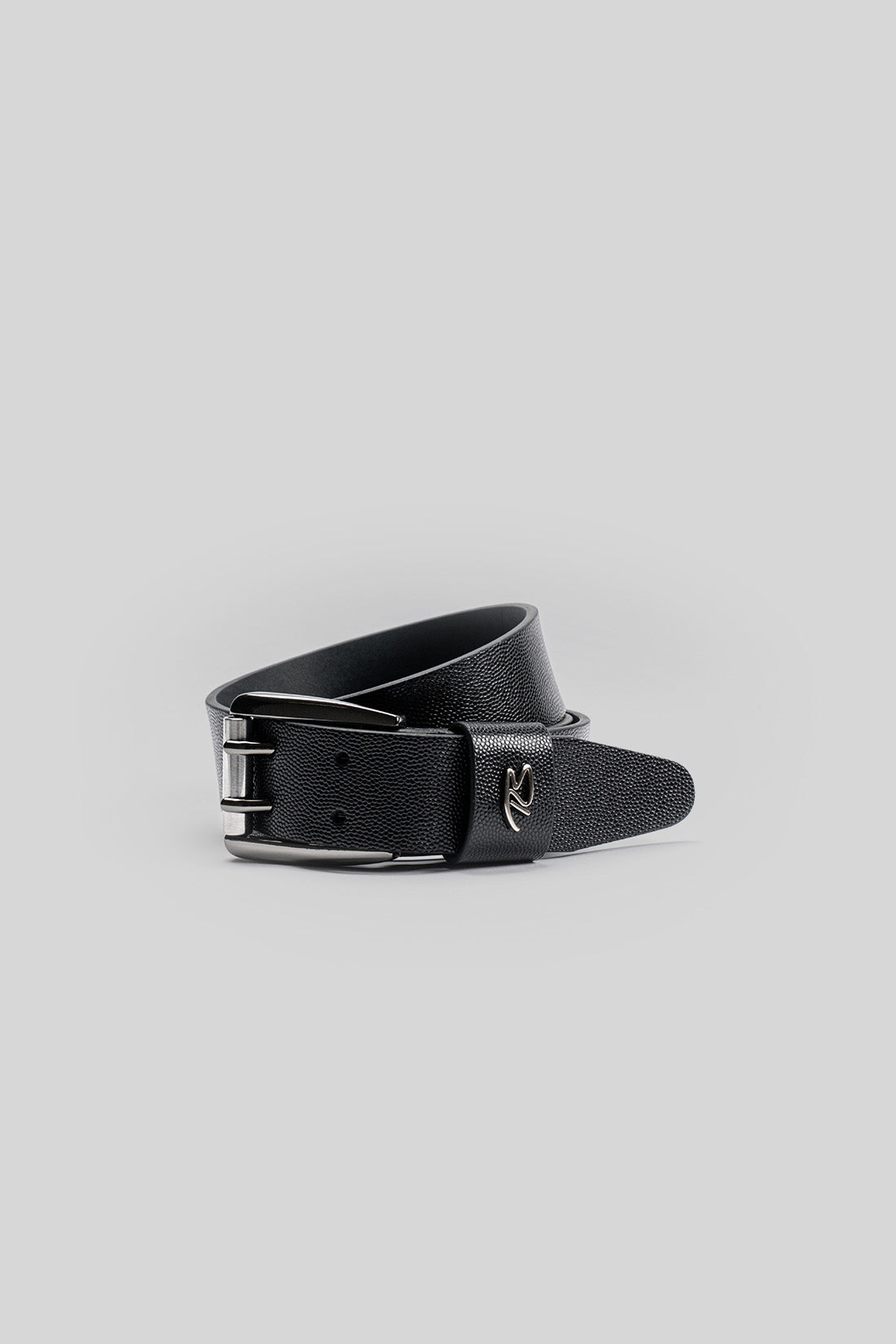 Black leather belt with textured grain surface and silver-toned buckle closure.