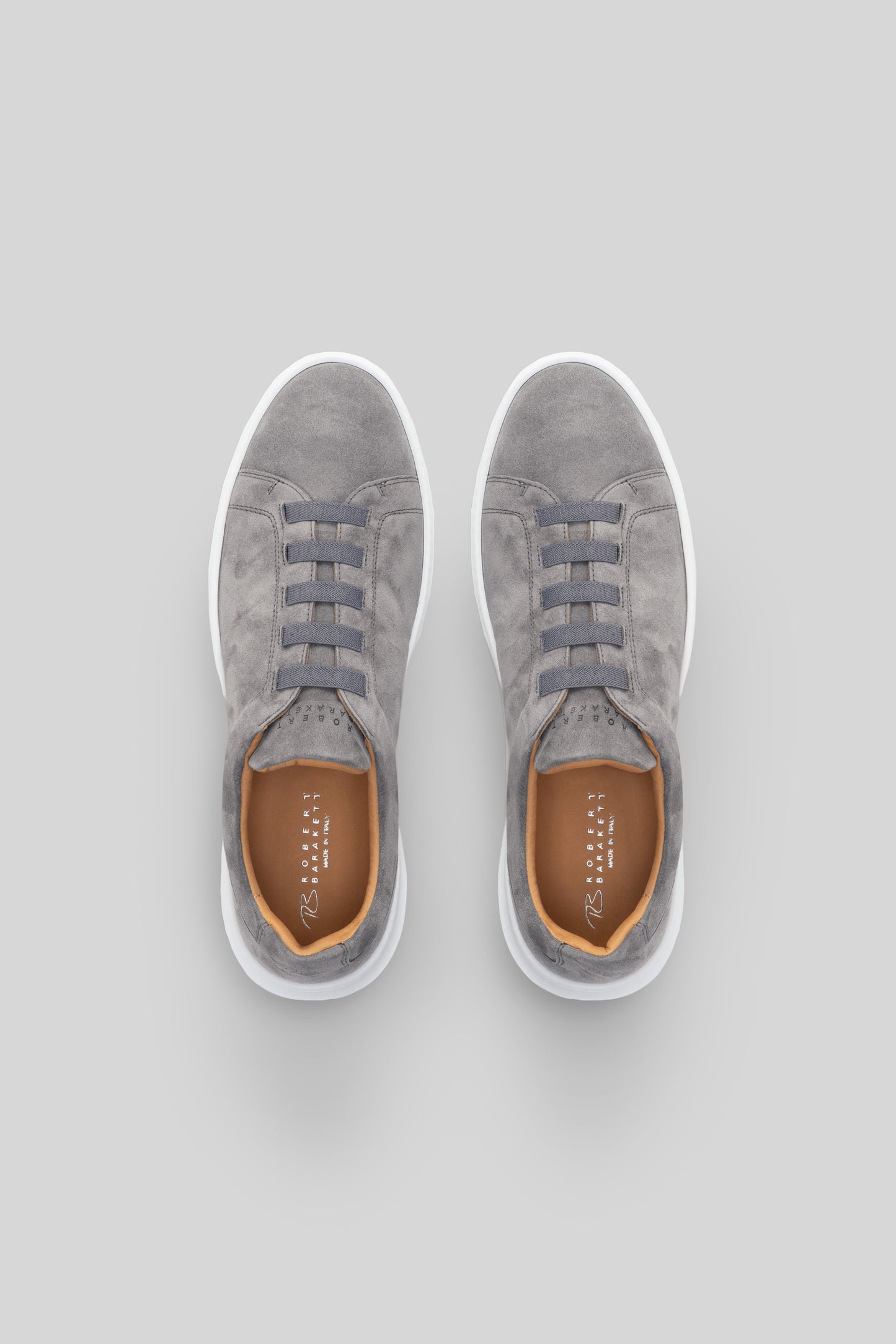 Gray suede lace-up sneaker with white sole and tan interior, shown from above.