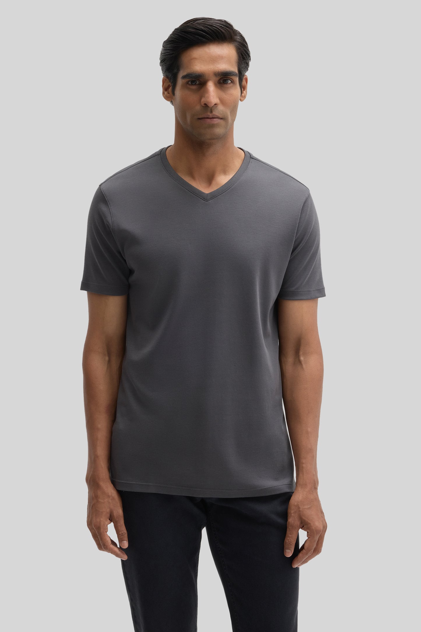 Man wearing charcoal gray V-neck short-sleeve tee with black pants.