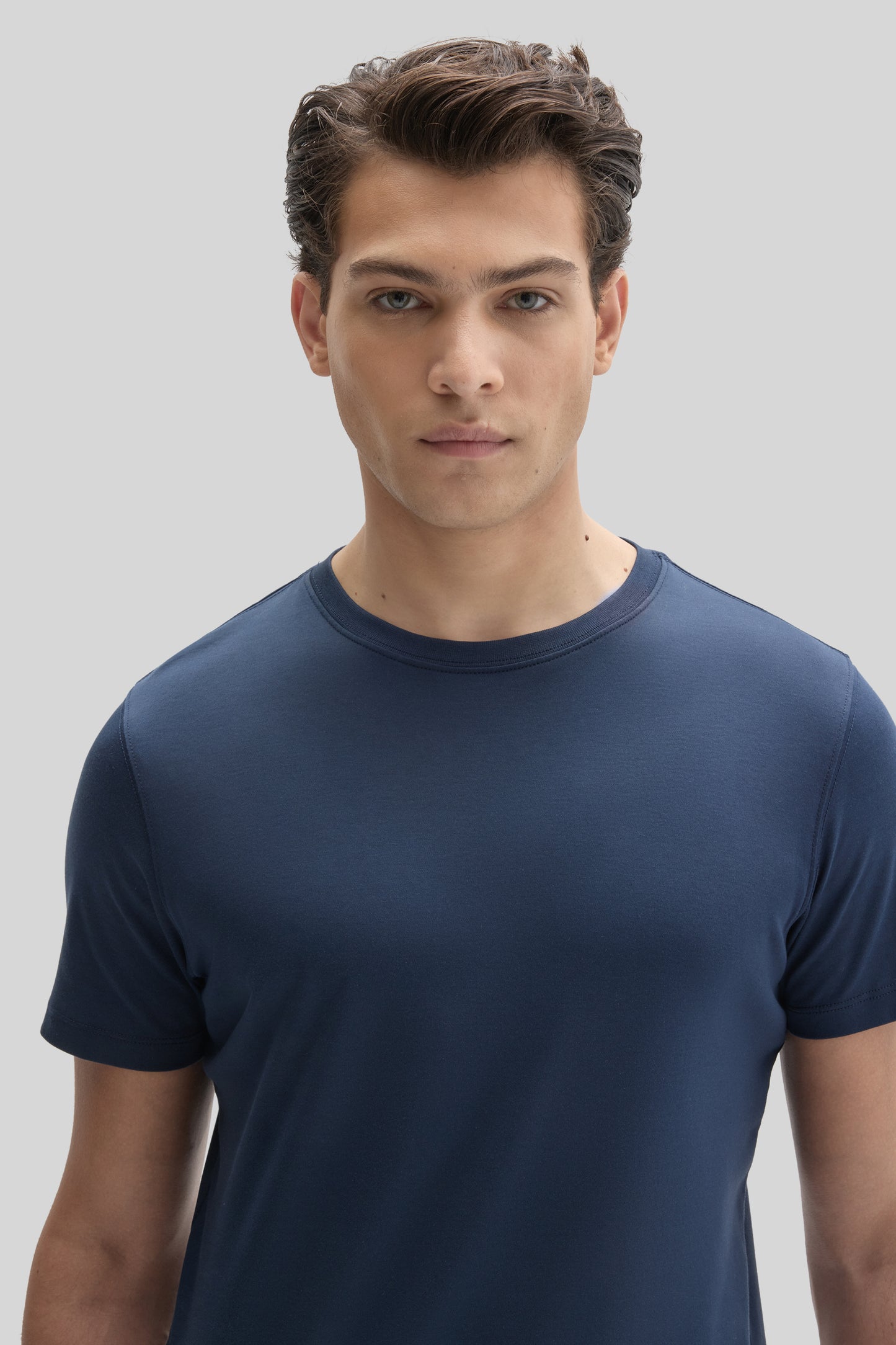 Man wearing a navy blue short-sleeve crew neck tee with a fitted silhouette.