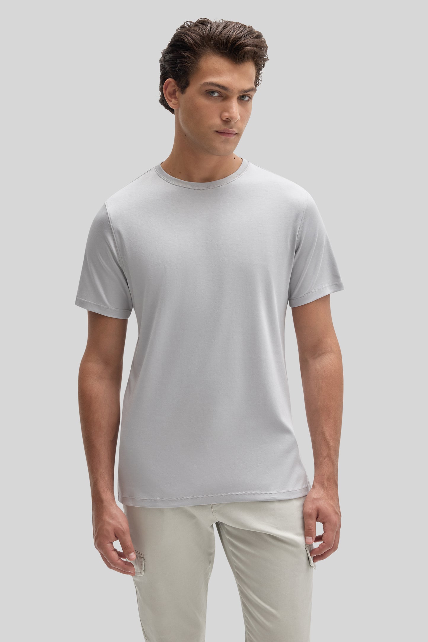 Man wearing light gray crew neck t-shirt with short sleeves and cream-colored pants.
