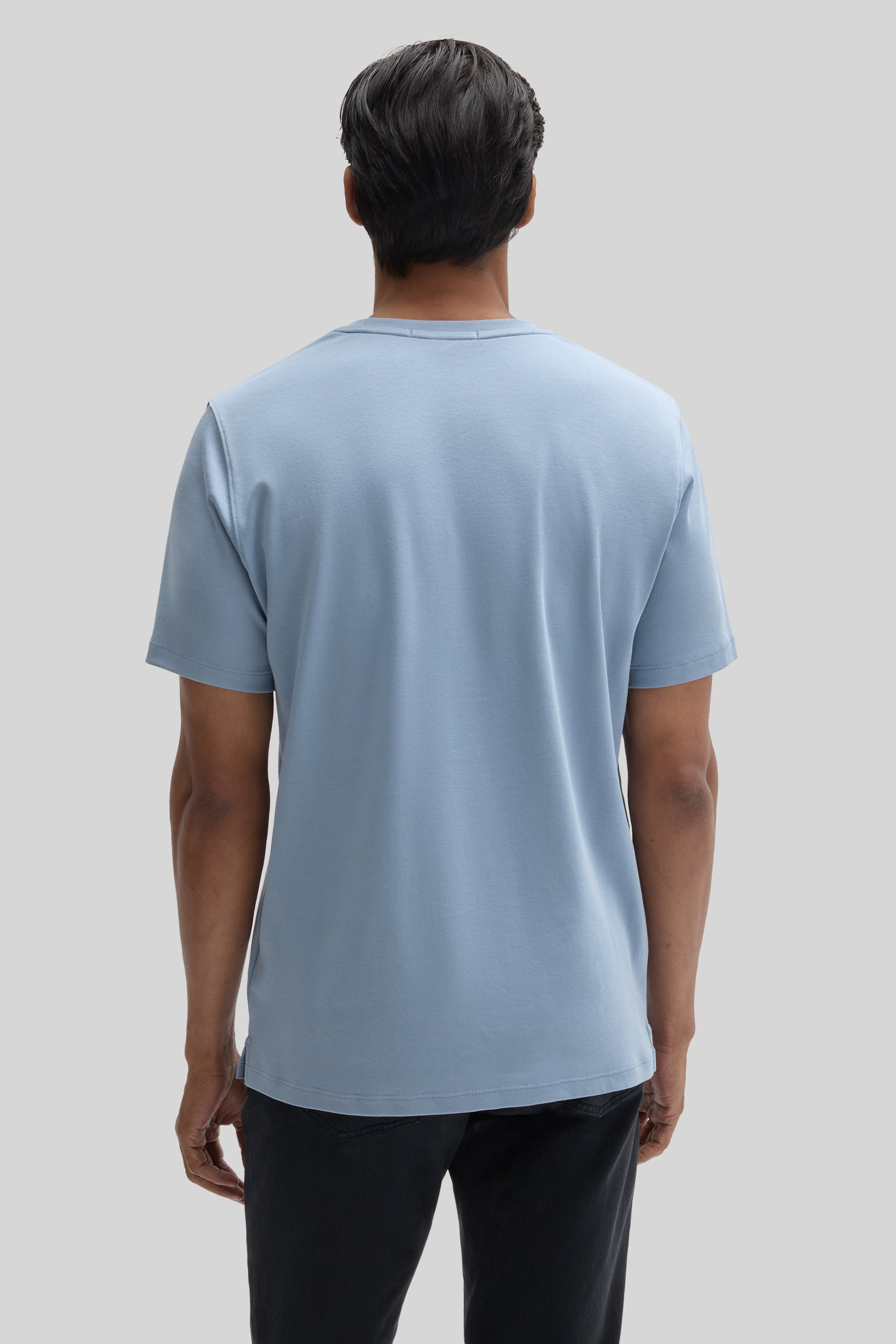 Man wearing light blue short-sleeve crew neck t-shirt, back view.