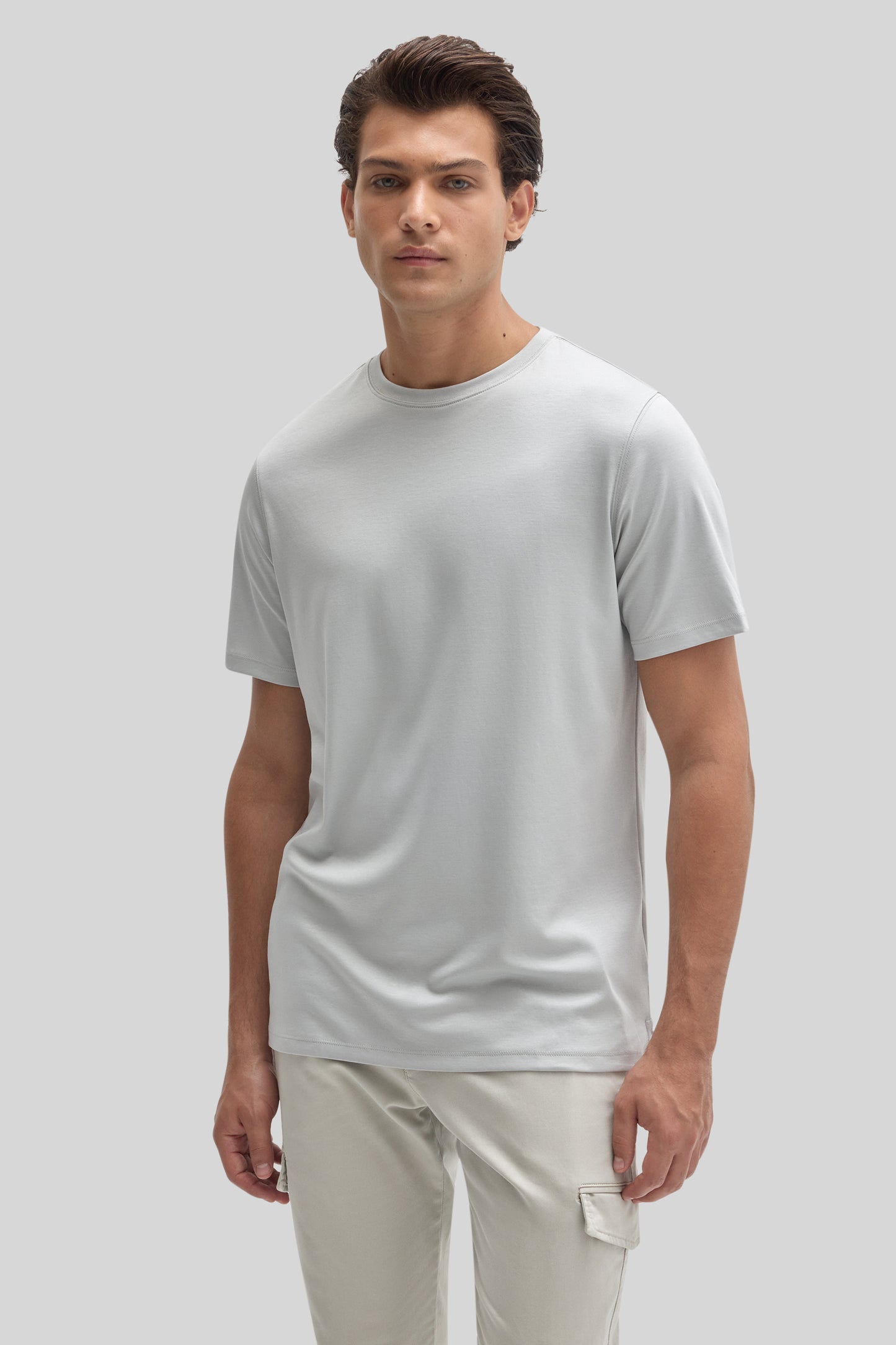Man wearing a light gray short-sleeve crew neck t-shirt with cream-colored cargo pants.