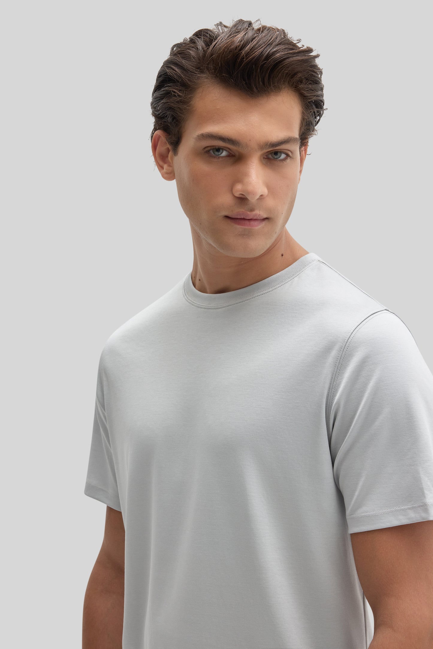 Man wearing a light gray crew-neck short-sleeve t-shirt against a neutral background.