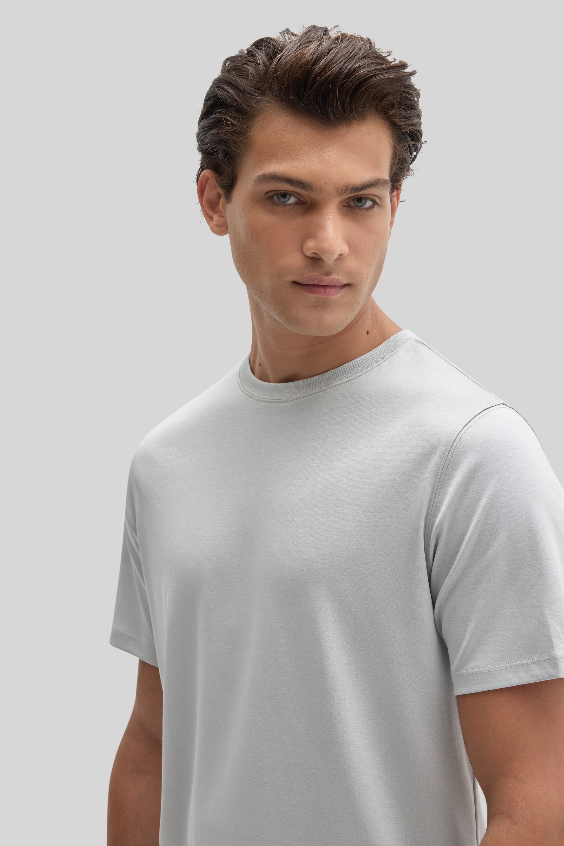 Man wearing a light gray crew-neck short-sleeve t-shirt against a neutral background.