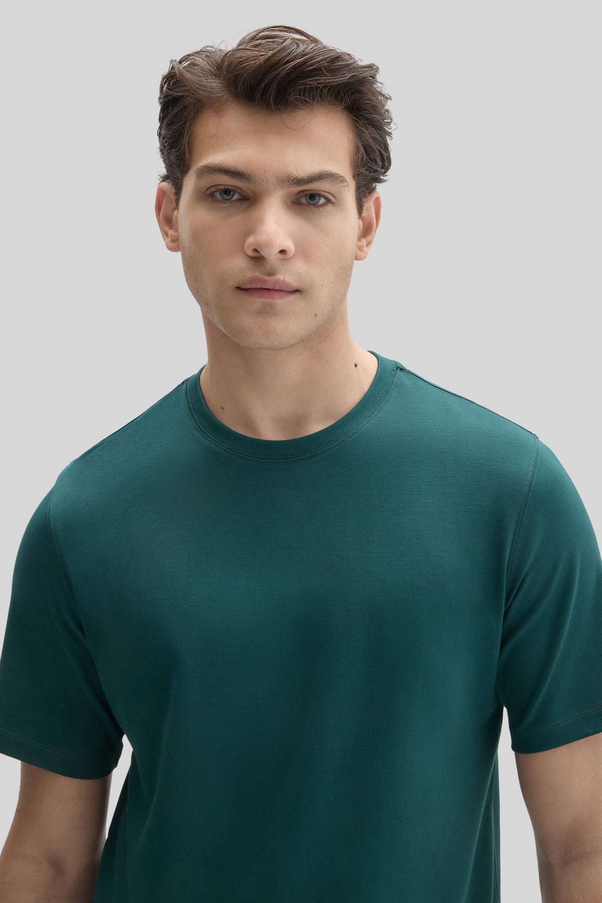 Man wearing a teal crew-neck short-sleeve t-shirt.