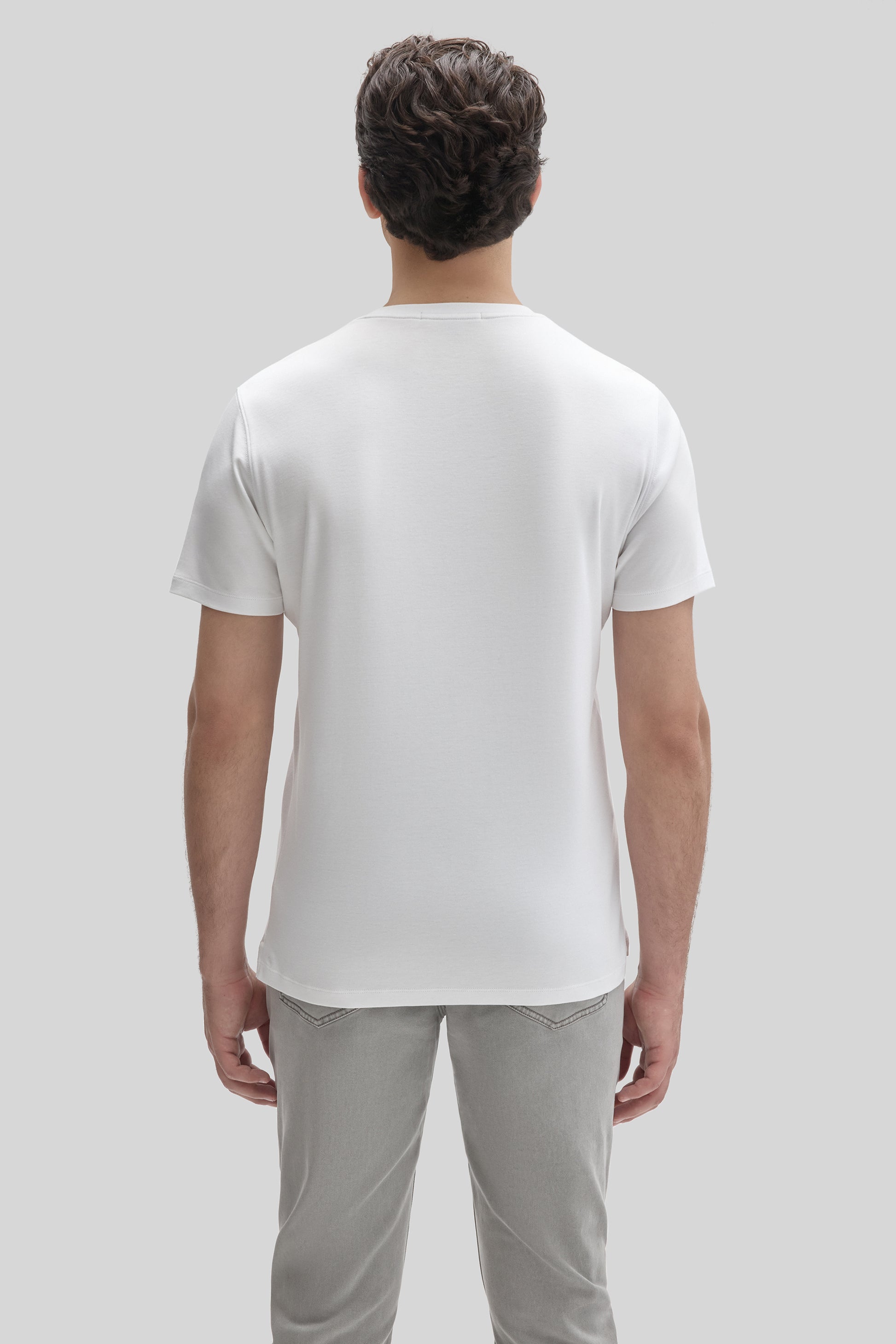 Man wearing white short-sleeve t-shirt, back view.
