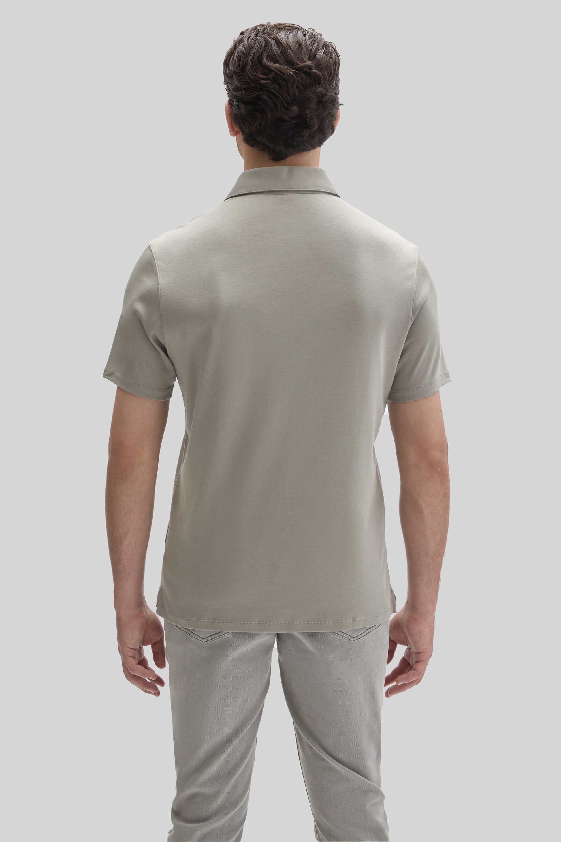 Man wearing a light gray short-sleeve polo shirt with a collared neckline, shown from behind.