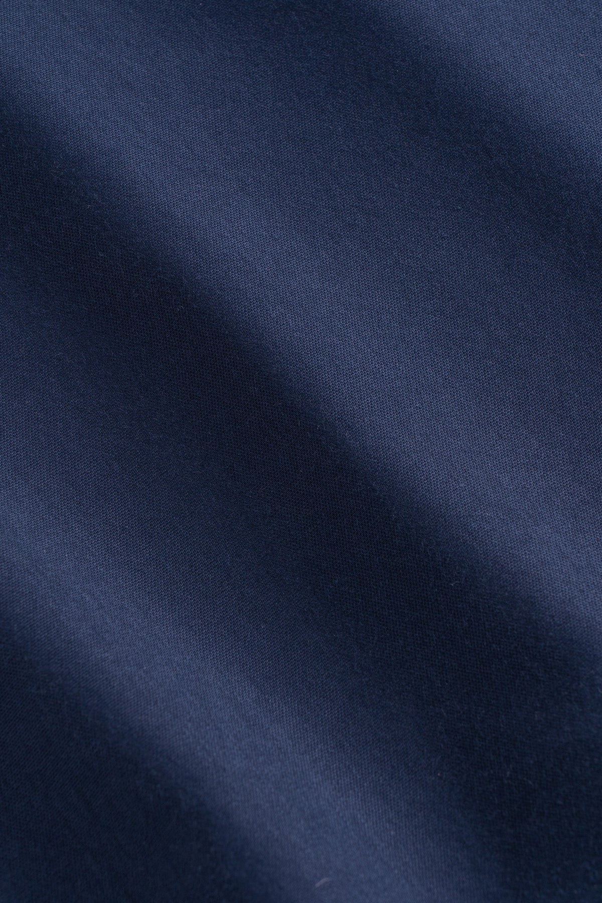 Navy blue ribbed knit fabric with a textured surface and natural draping folds.