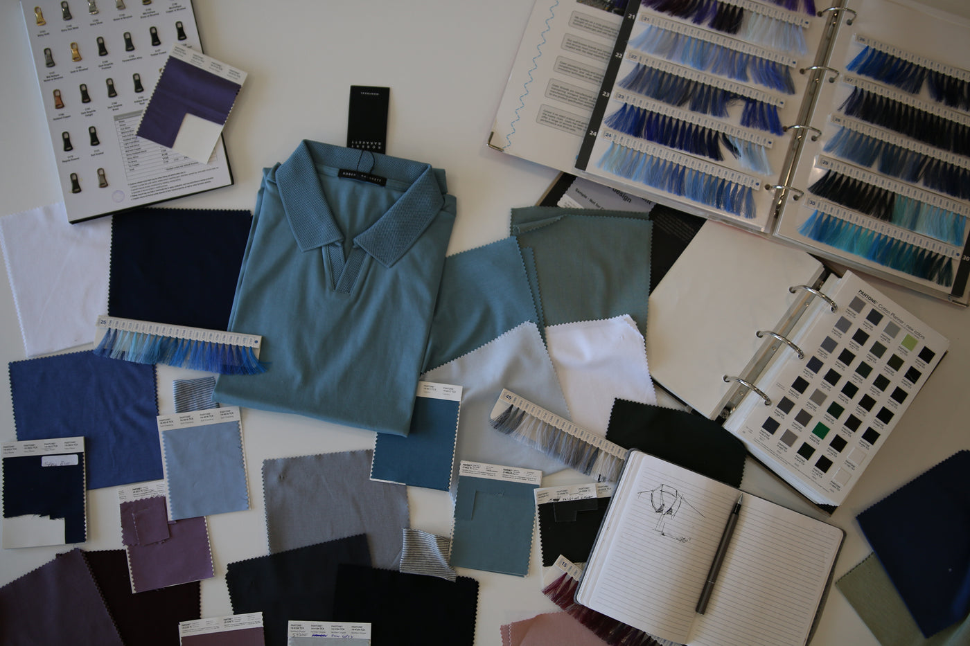 Barakett Polo in blue surrounded by a variety of fabric & color samples 