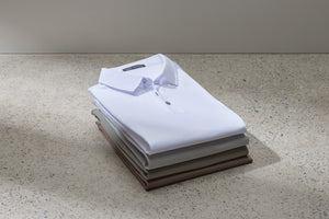 polo short sleeve shirts folded and stacked on a table