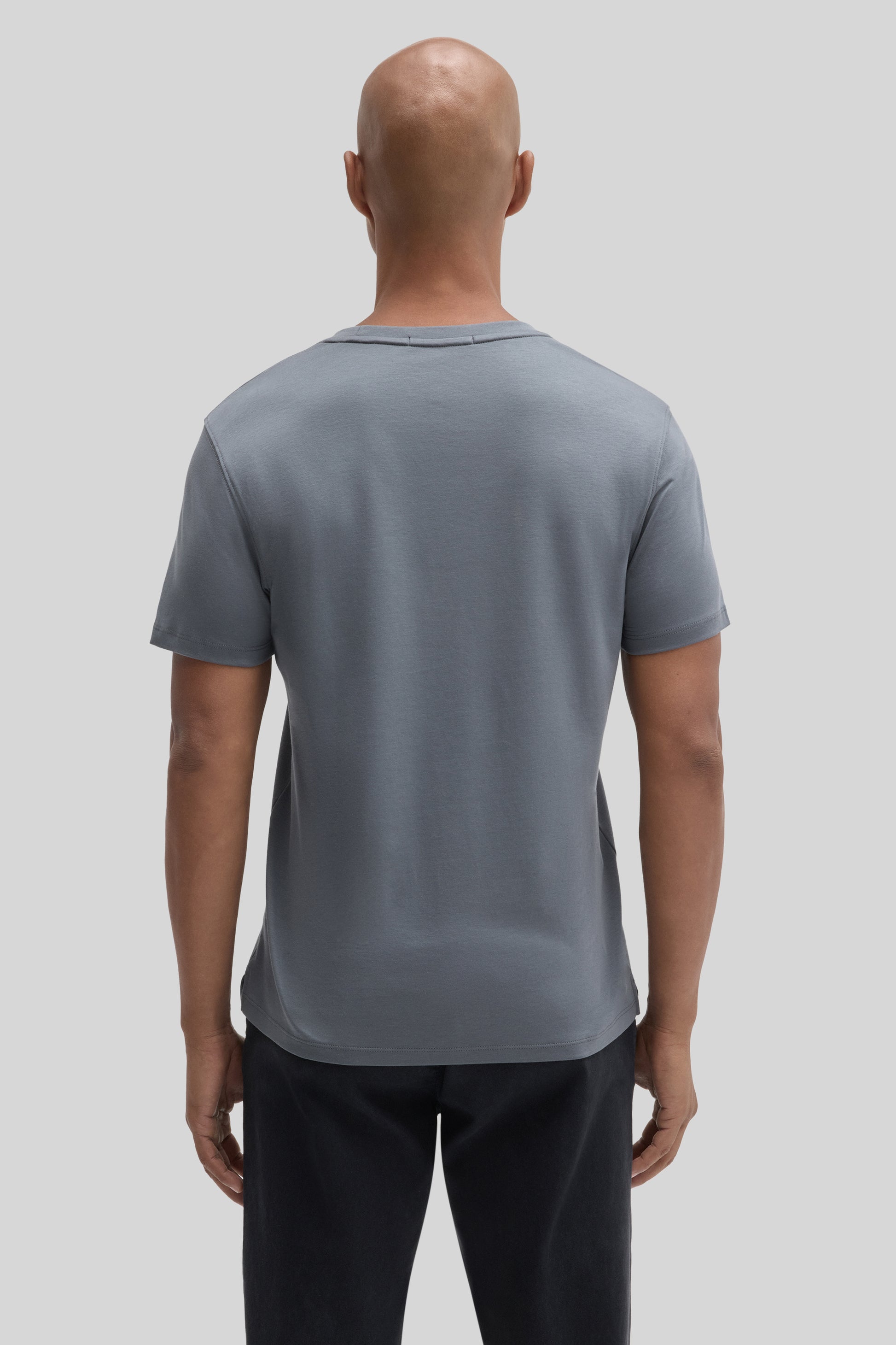 Man wearing slate blue short-sleeved t-shirt with crew neckline, shown from back view.