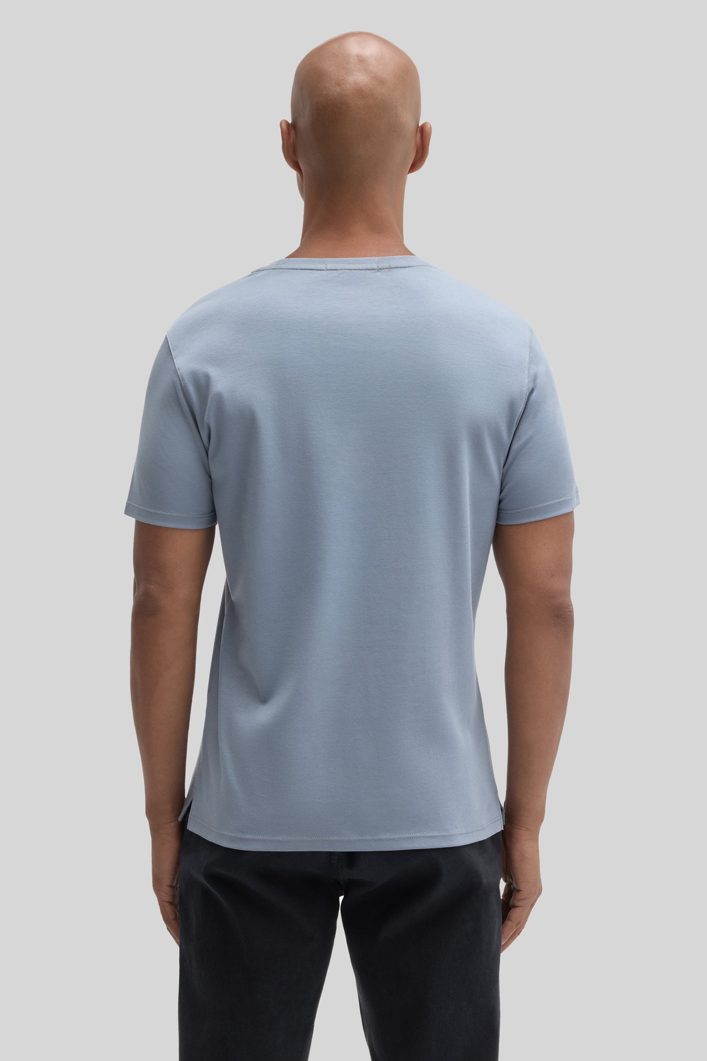 Man wearing light blue short-sleeve t-shirt with crew neckline, shown from back view against neutral background.