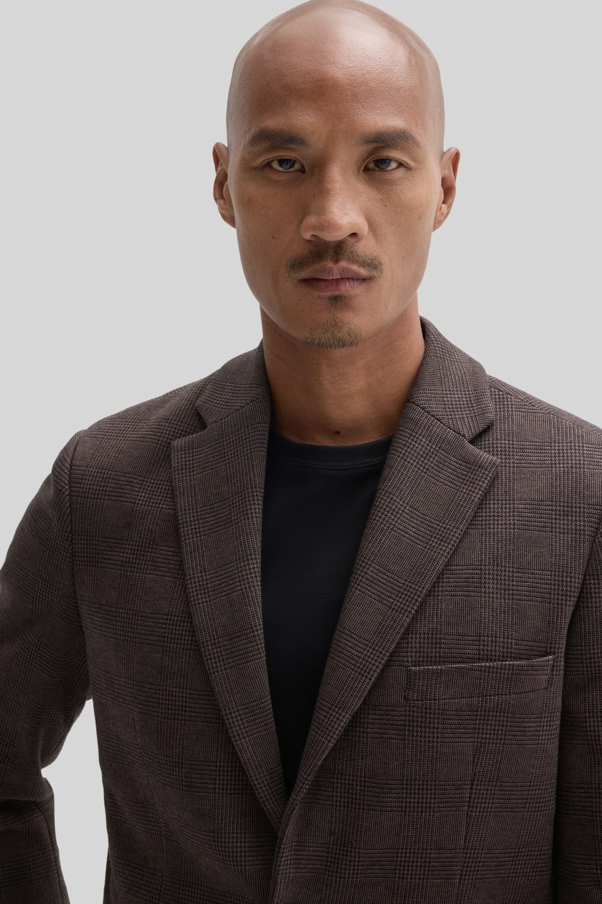 Man wearing brown plaid Pascal Sportcoat over black crew neck shirt.