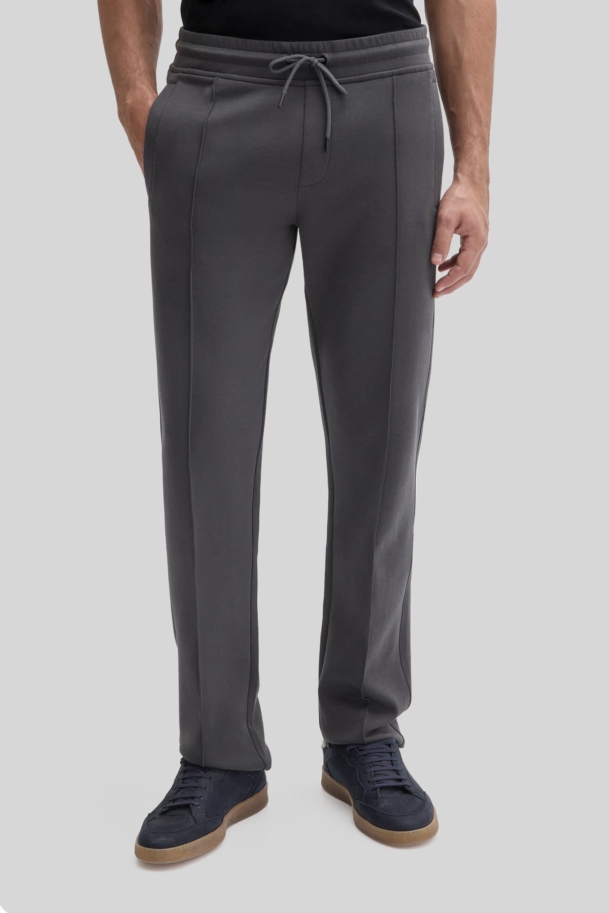 Charcoal gray jogging pants with drawstring waistband and straight legs, worn with navy sneakers.