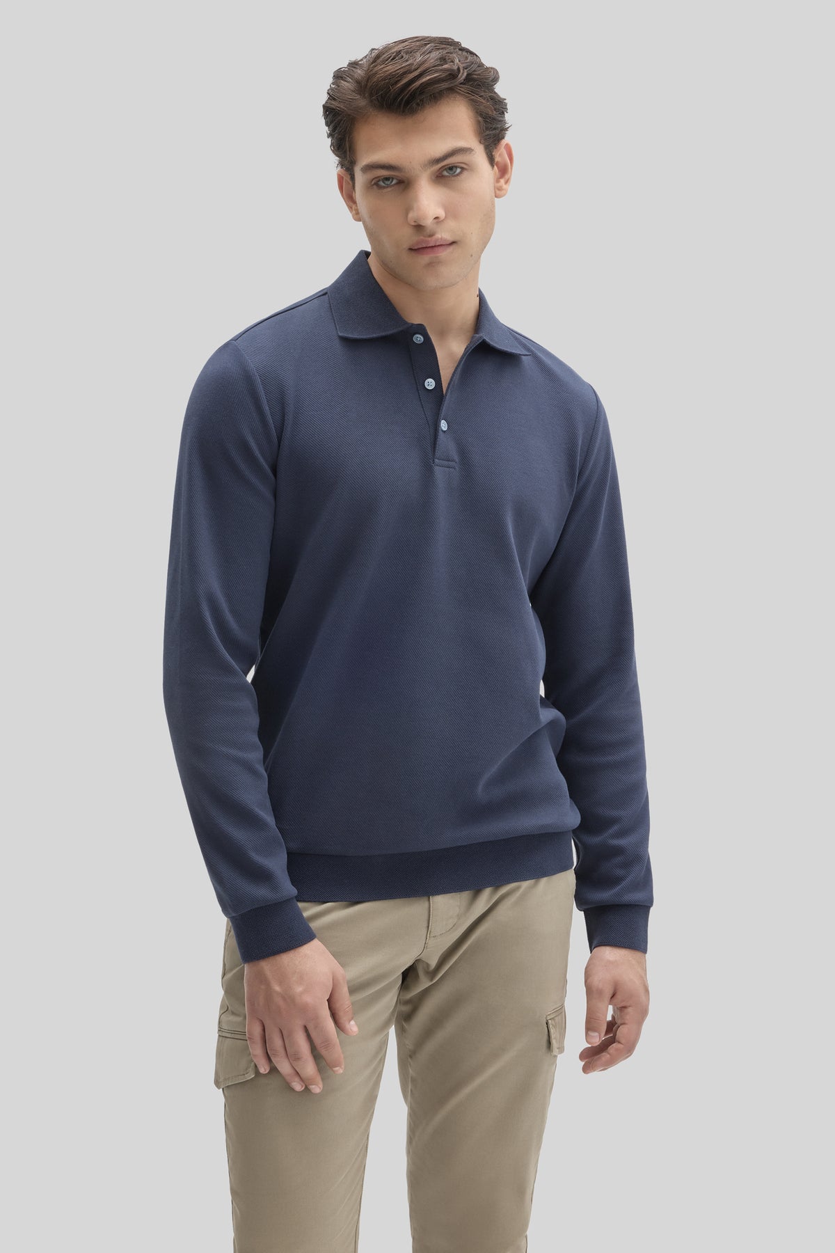 Navy long sleeve polo shirt with white button placket worn with khaki cargo pants.