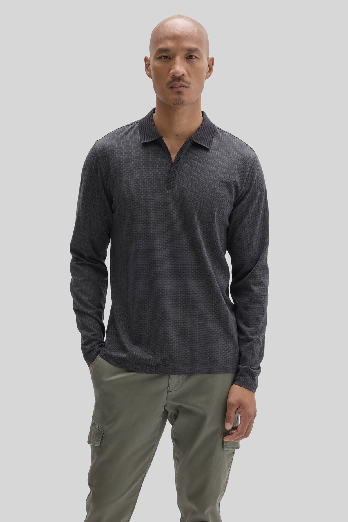 Charcoal long sleeve polo shirt with zip placket and textured fabric, worn with olive cargo pants.