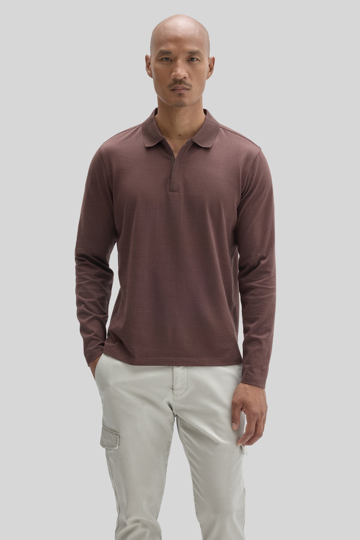 Mauve long-sleeve polo with textured fabric and zip placket neckline, paired with cream cargo pants.