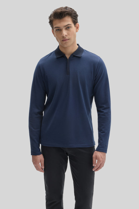 Navy long sleeve polo shirt with zip placket and textured knit fabric worn with black pants.