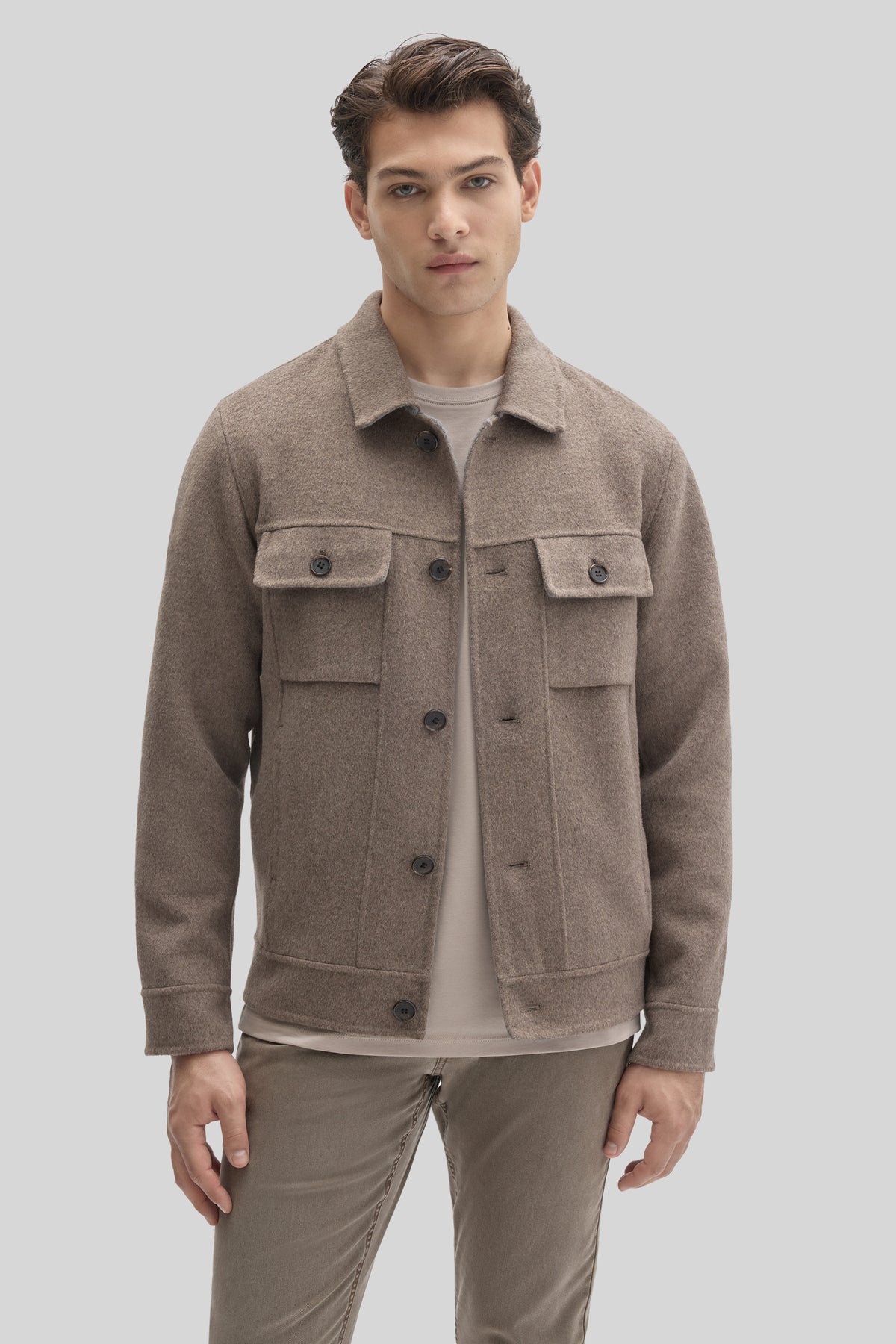 Beige buttoned jacket with collar and flap pockets worn over white t-shirt.