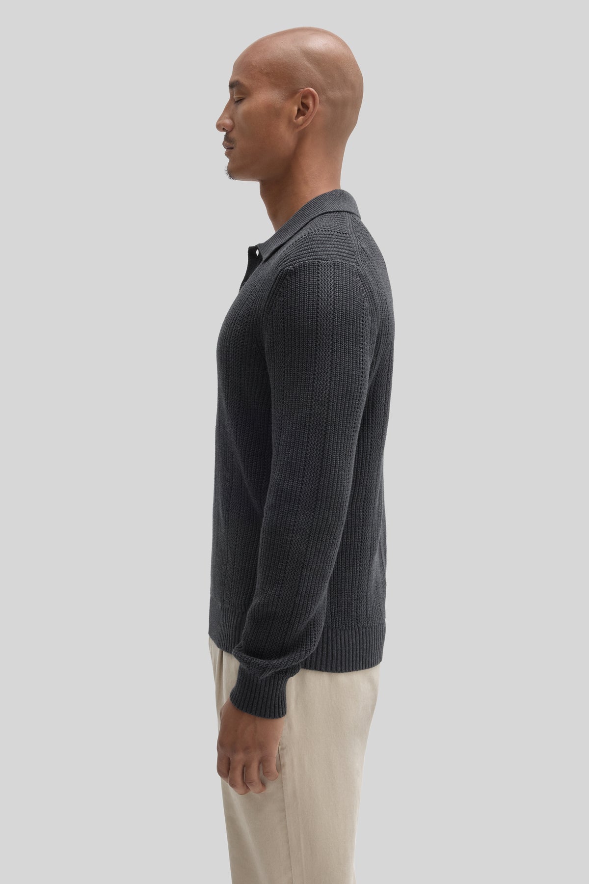 Charcoal ribbed knit polo sweater with collar, shown on model wearing cream pants.