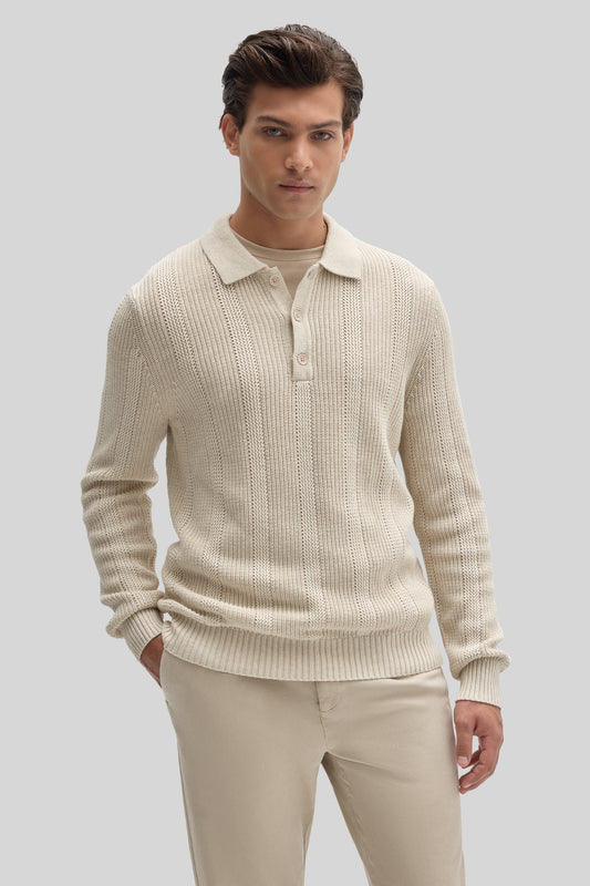 Cream ribbed sweater polo with collar and button placket worn with matching beige pants.