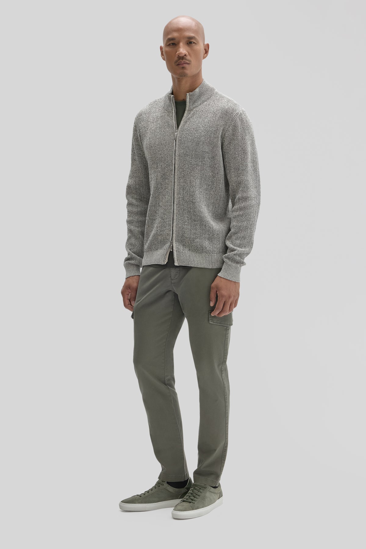 Men's gray full-zip mock neck sweater worn with olive cargo pants and gray sneakers.