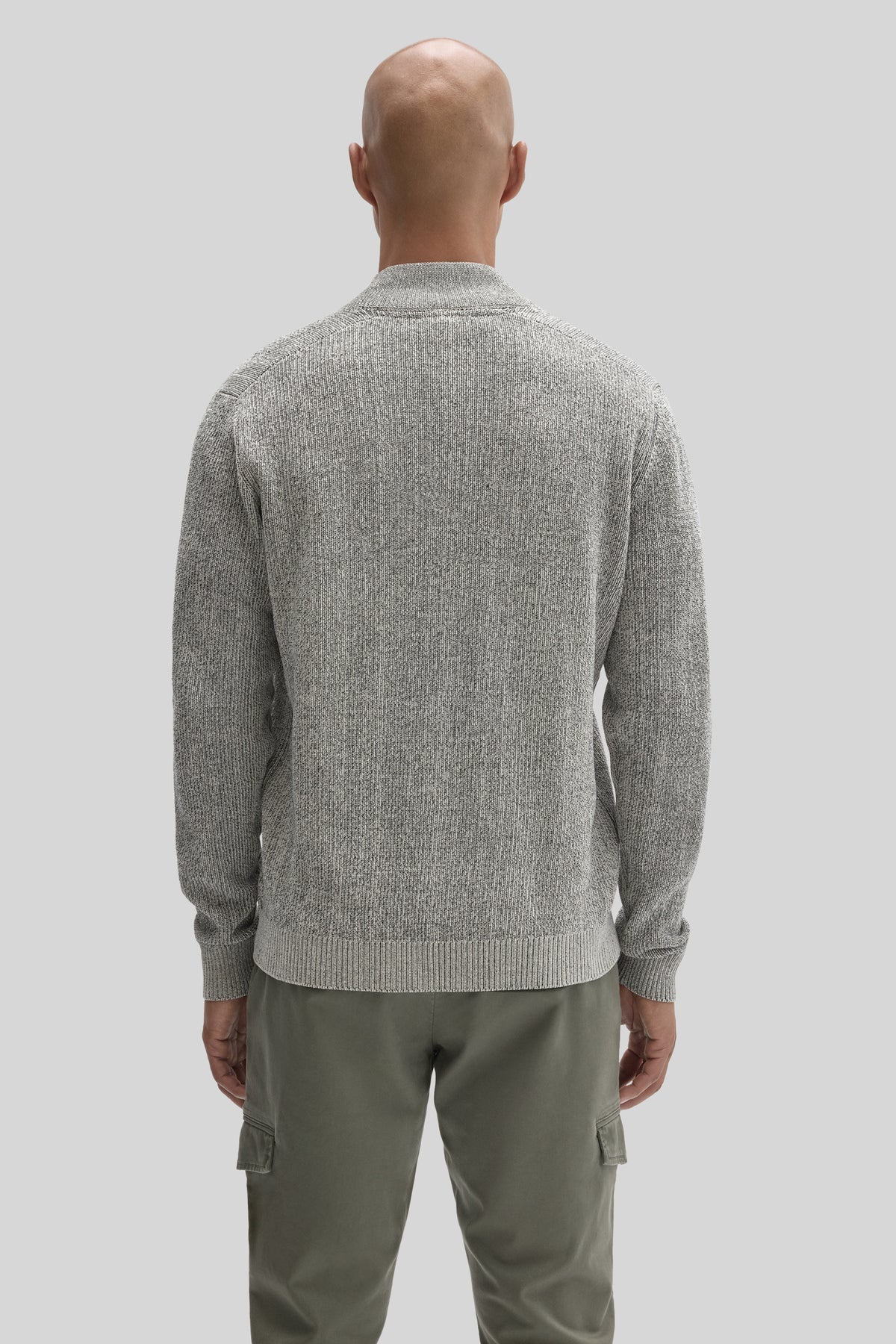 Light gray ribbed knit sweater with mock neck and full zip, shown from back on model wearing olive cargo pants.