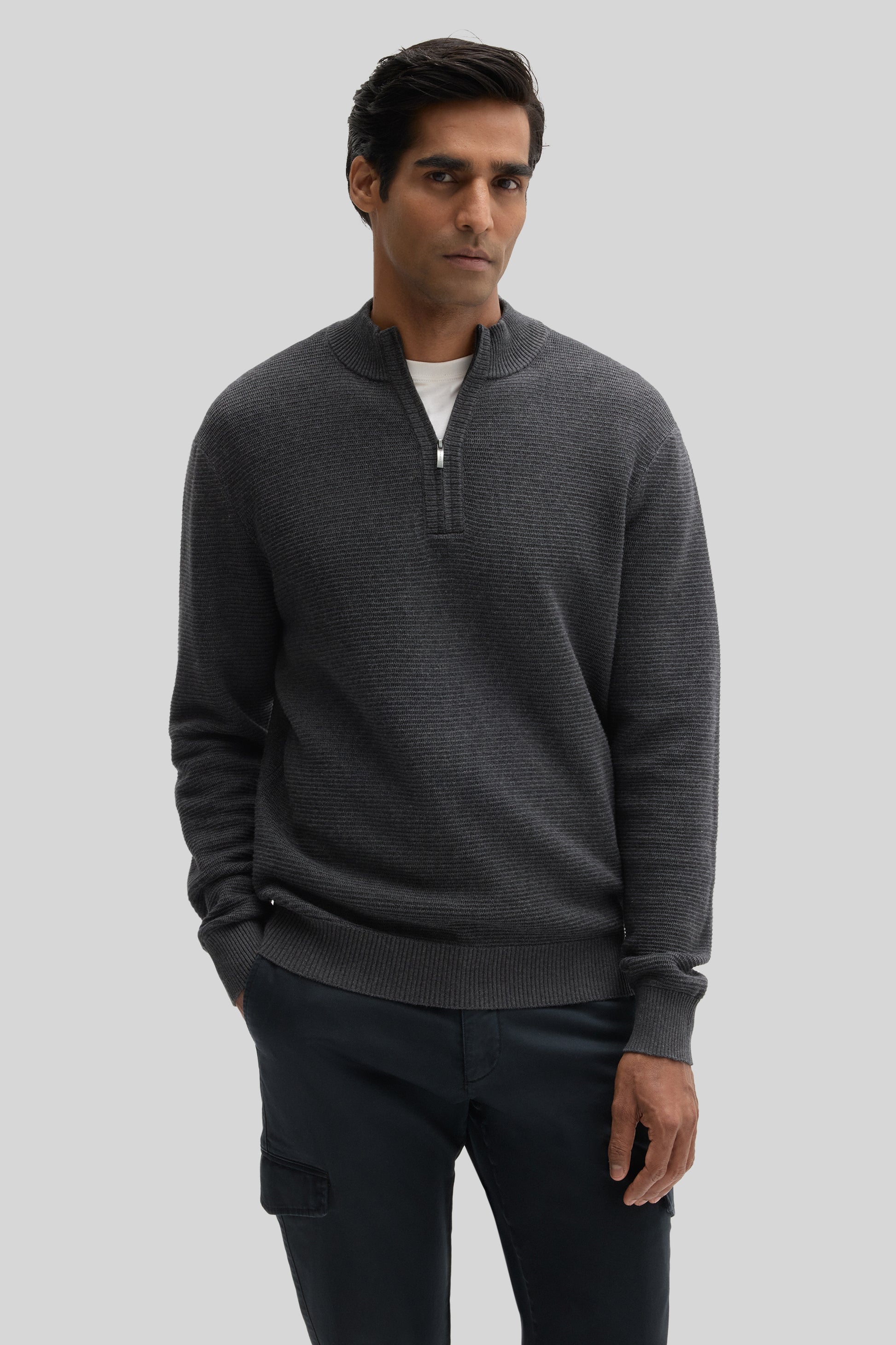 Charcoal gray quarter zip sweater with ribbed texture worn with white undershirt and dark pants.