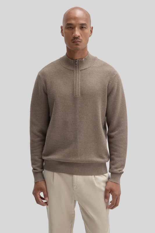 Beige quarter zip sweater with ribbed texture worn with cream pants.