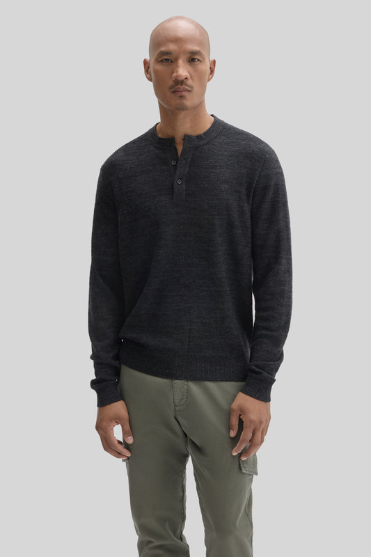 Man wearing charcoal henley sweater with button placket and olive green cargo pants.