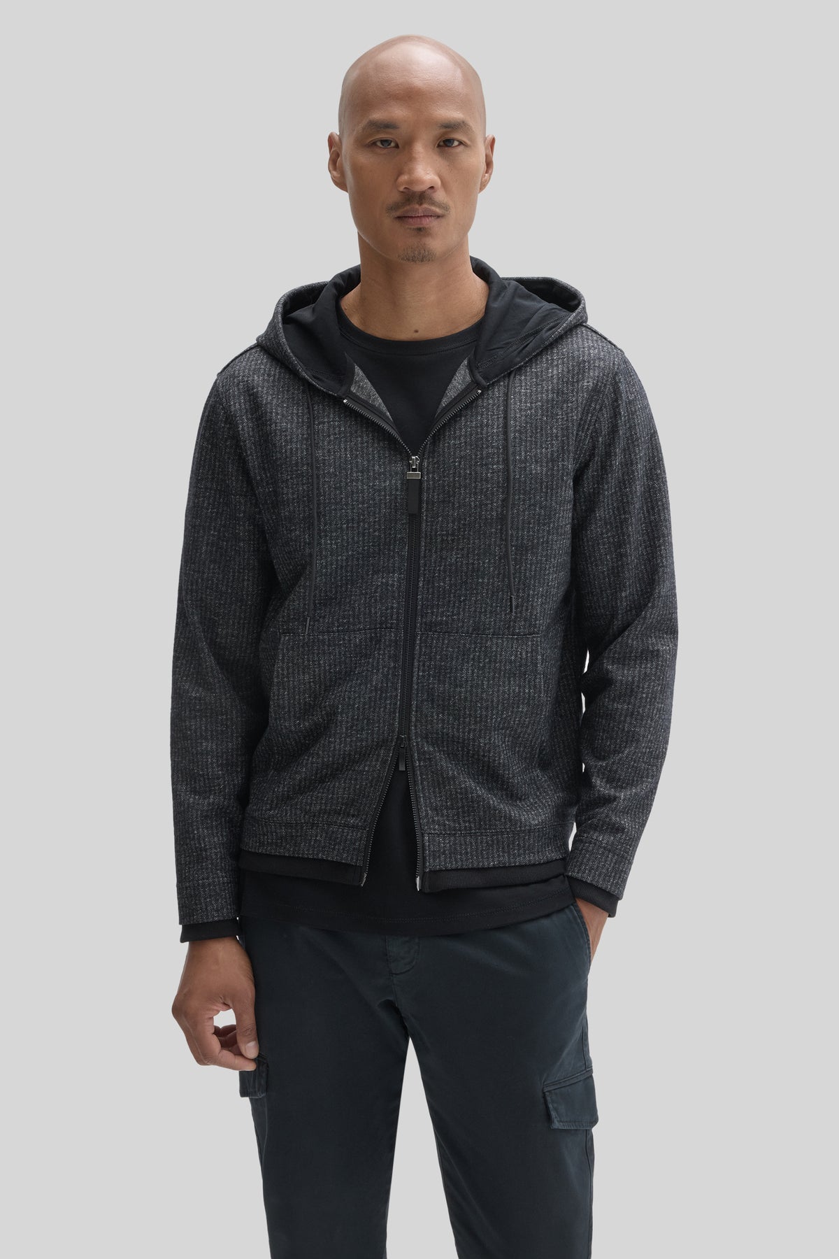 Charcoal ribbed full zip hoodie with black lining and drawstrings, worn over black shirt.