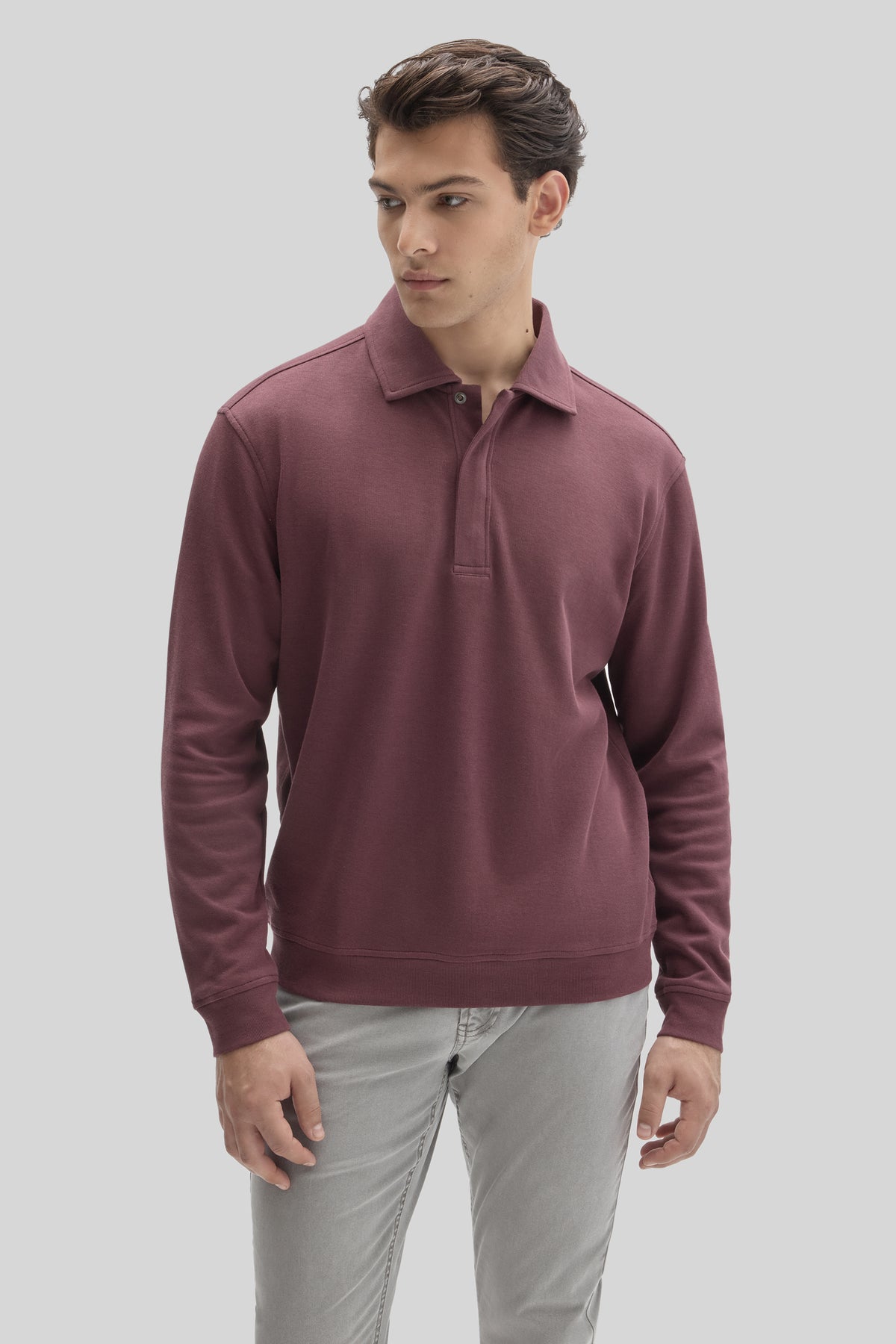 Burgundy long-sleeve polo shirt with snap closure and chest pocket, worn with light gray pants.