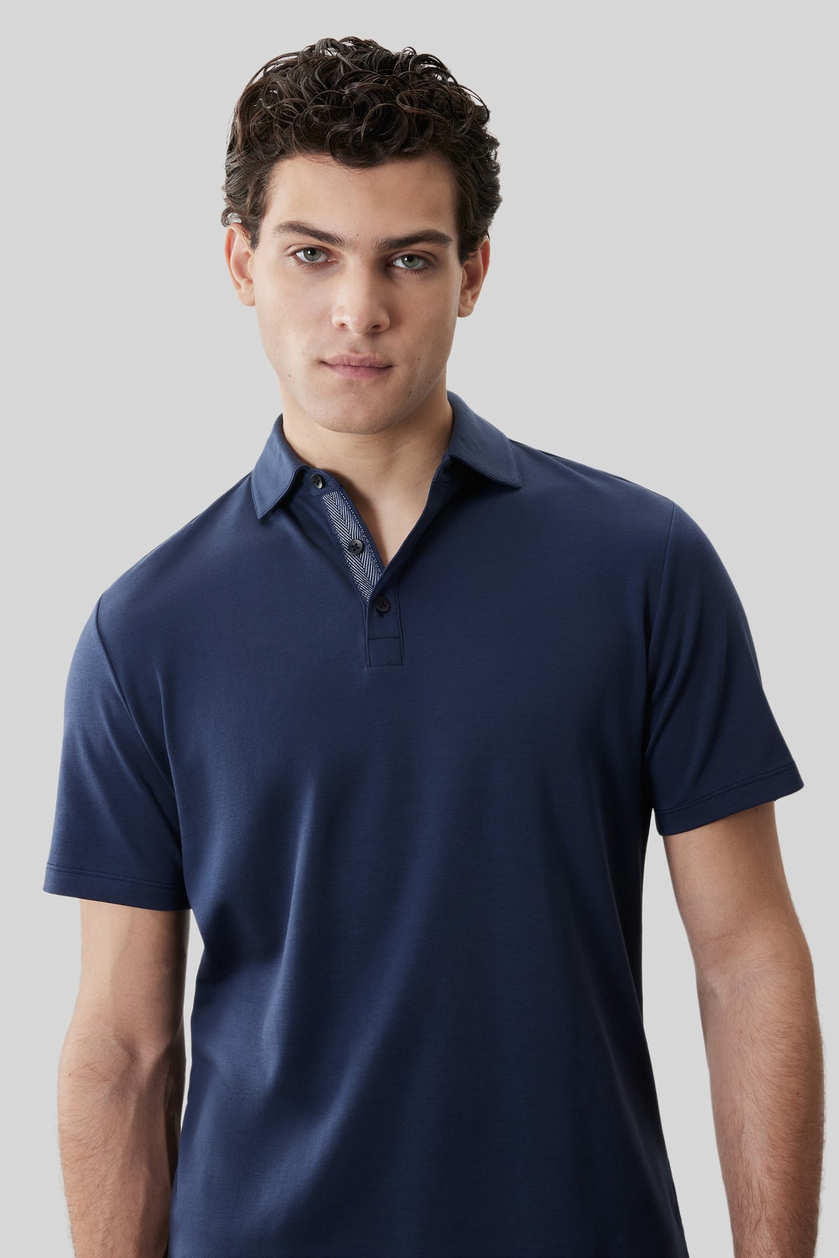Navy short-sleeve polo shirt with herringbone pattern collar and button placket.