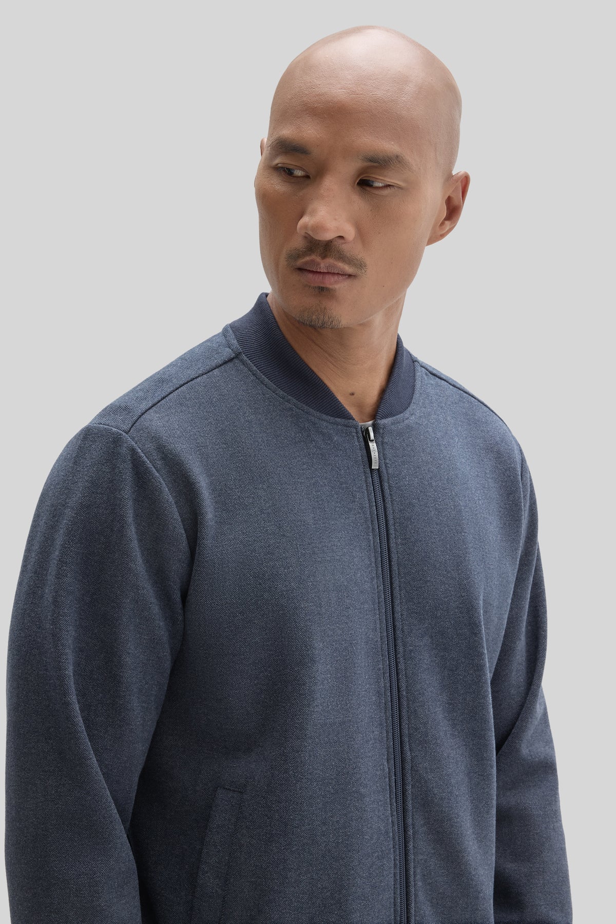 Navy blue baseball collar jacket with front zipper and ribbed neckline, shown on model.