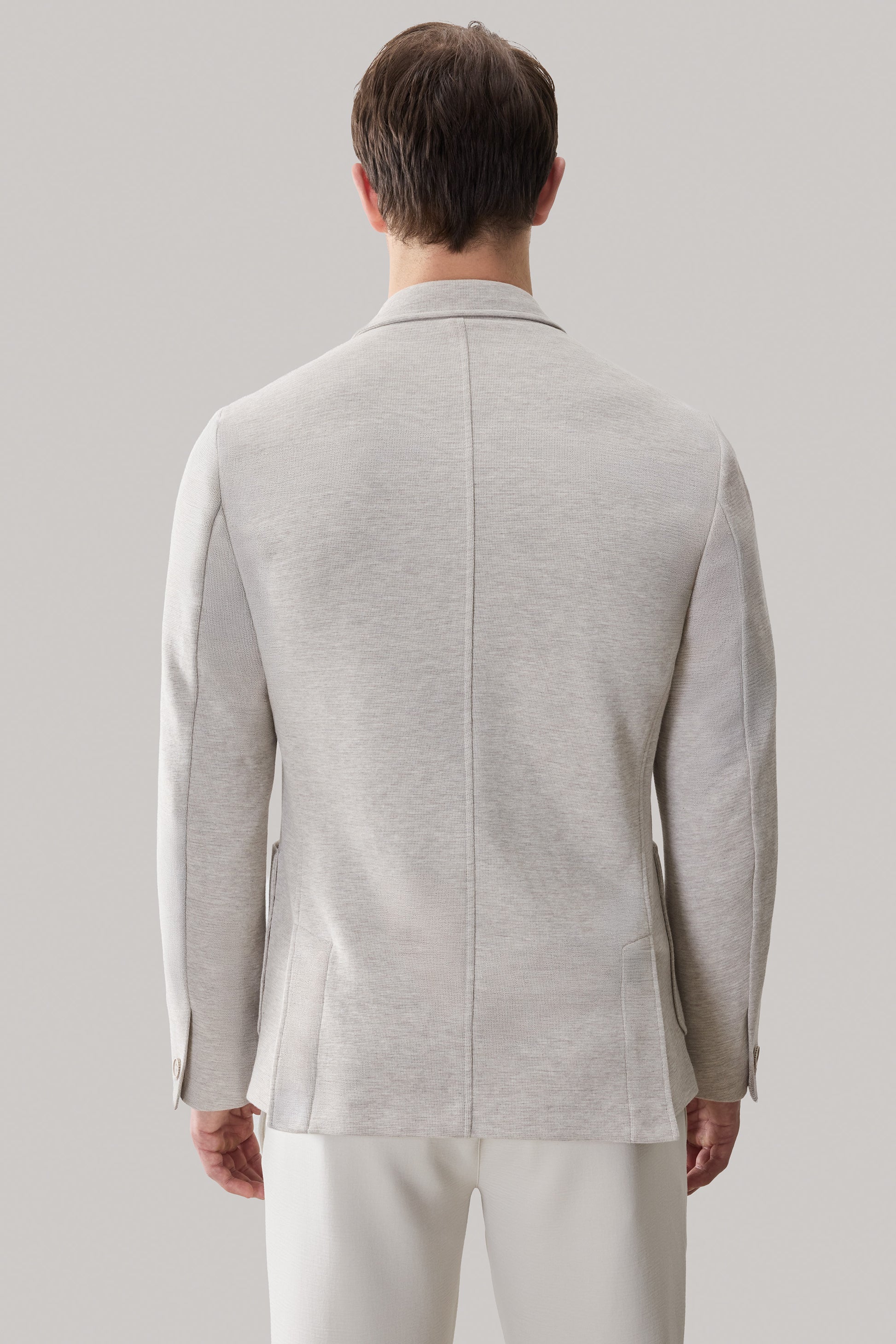 Light gray sportcoat with notch lapels, patch pockets, and button cuffs, shown from the back.