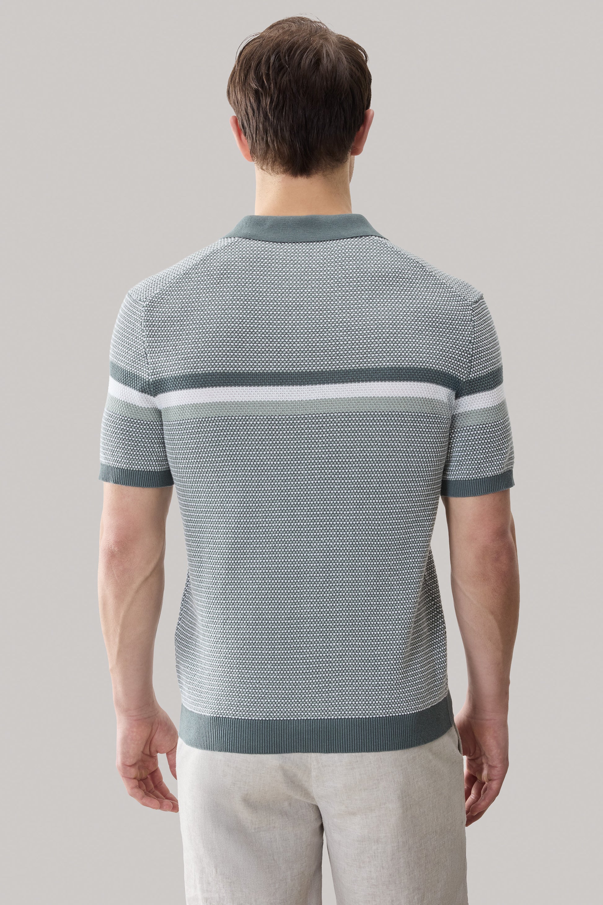 Light blue and gray striped knit polo shirt with open collar and ribbed cuffs, shown from back view.