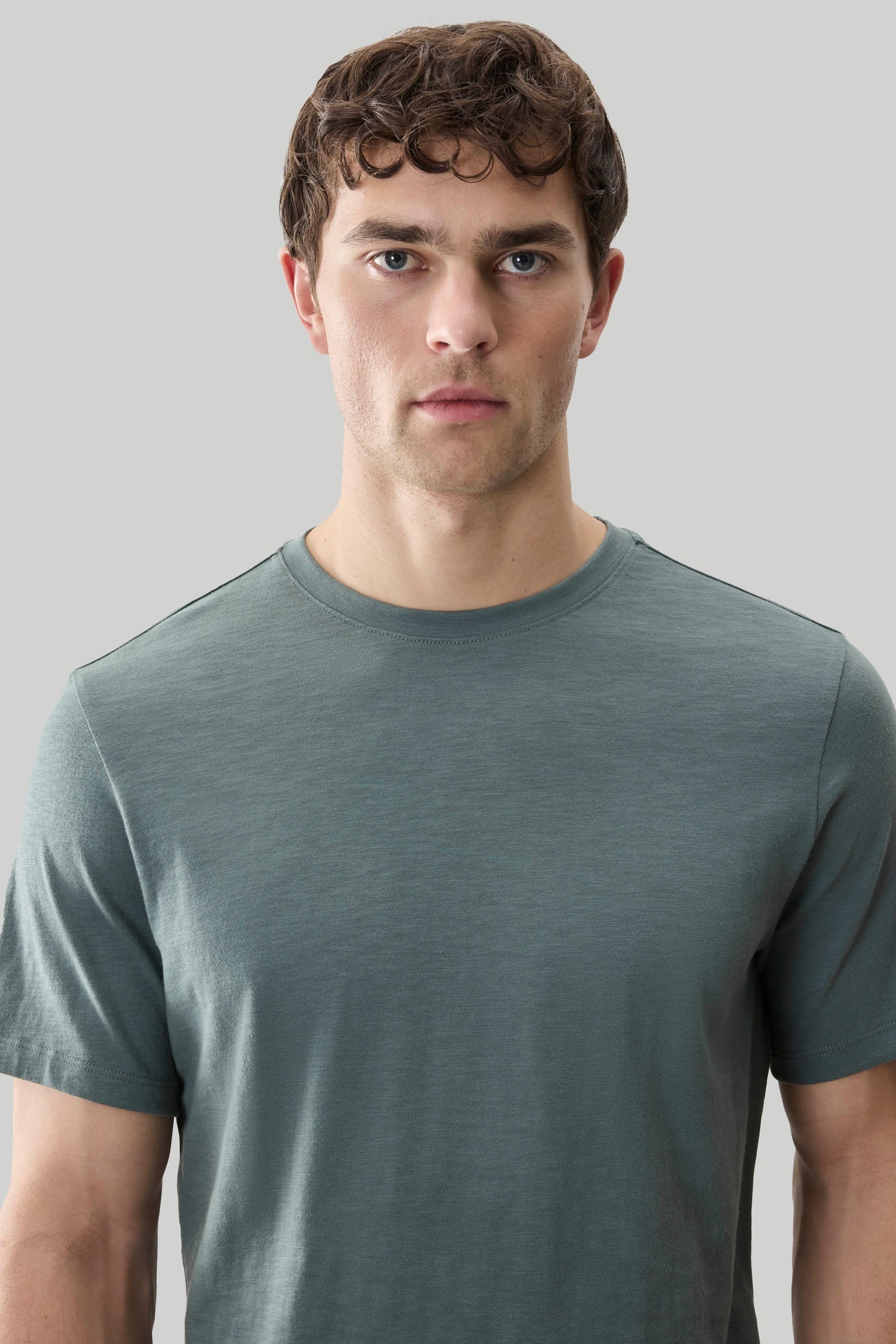 Man wearing sage green short-sleeve crew neck tee with textured fabric.