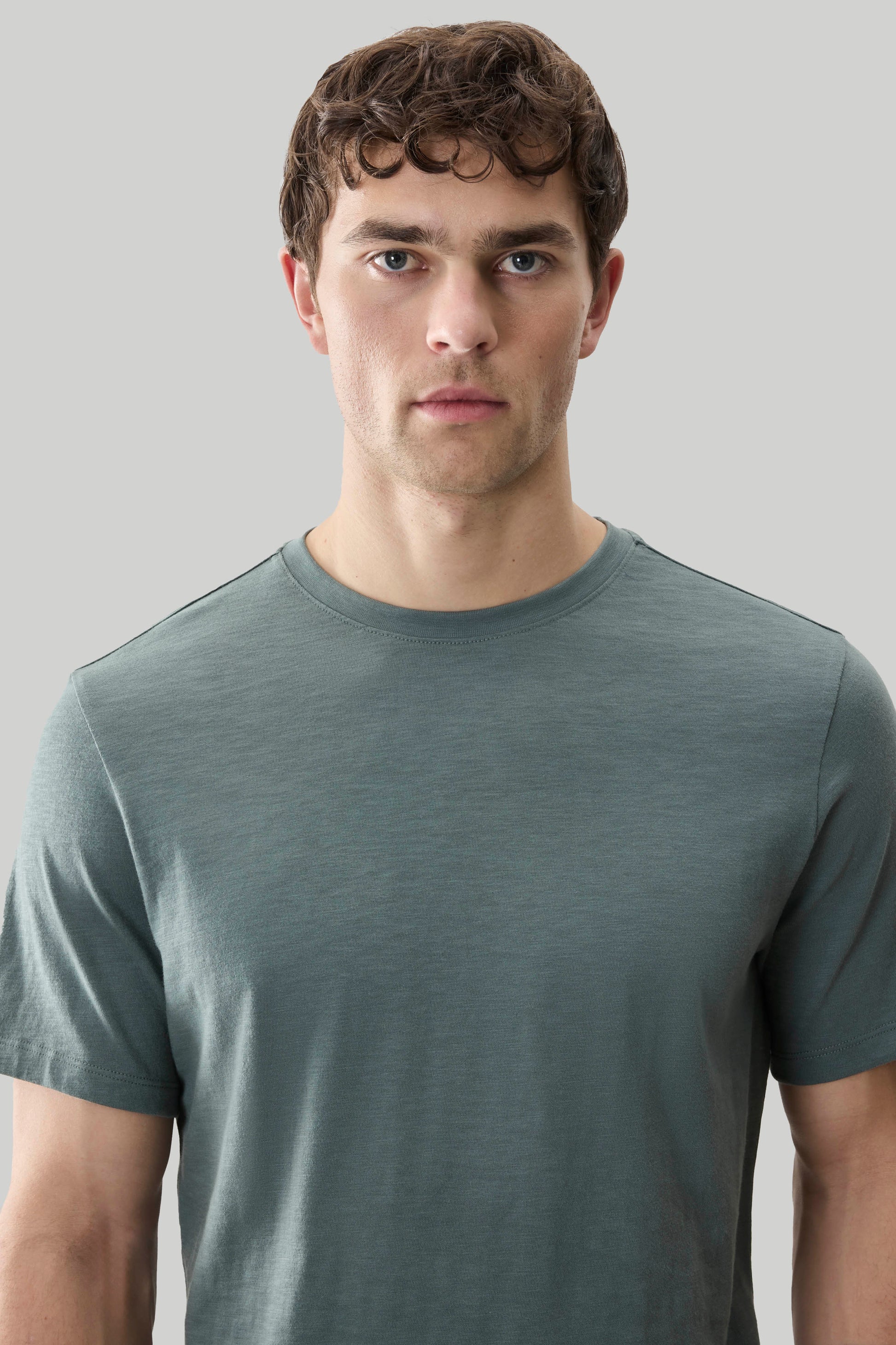 Man wearing sage green short-sleeve crew neck tee with textured fabric.
