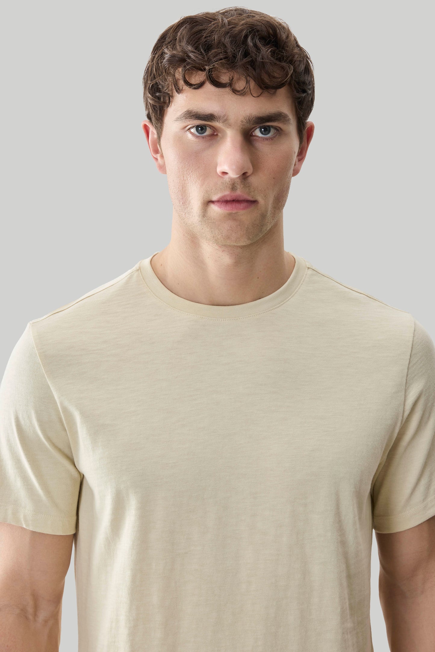 Man wearing a beige short-sleeve crew neck tee with textured slub fabric.