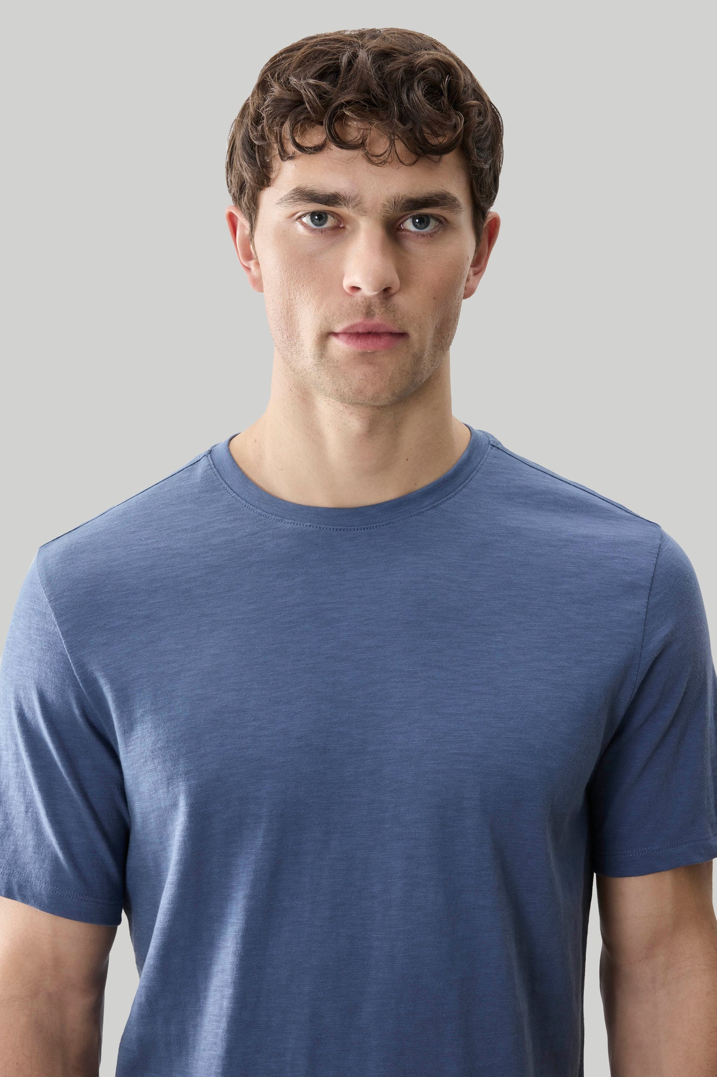 Man wearing a blue short-sleeve crew neck tee with textured slub fabric.