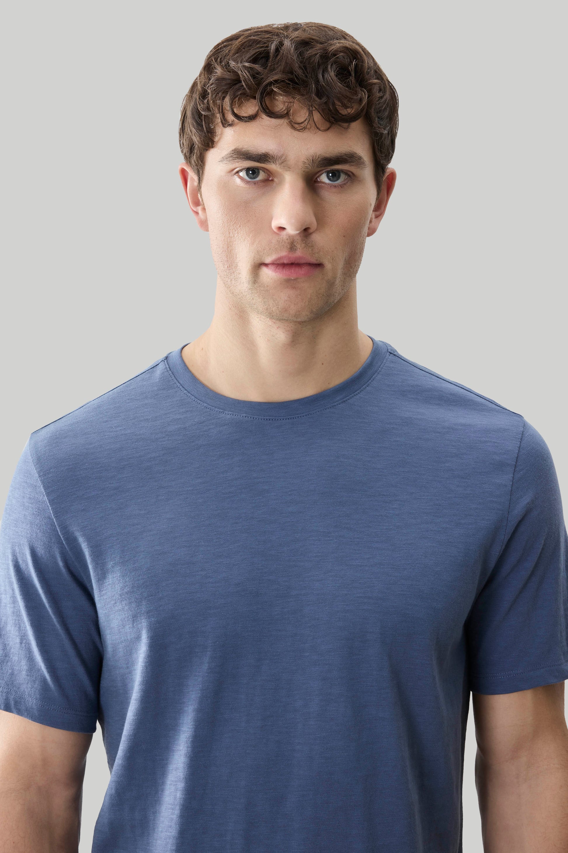 Man wearing a blue short-sleeve crew neck tee with textured slub fabric.
