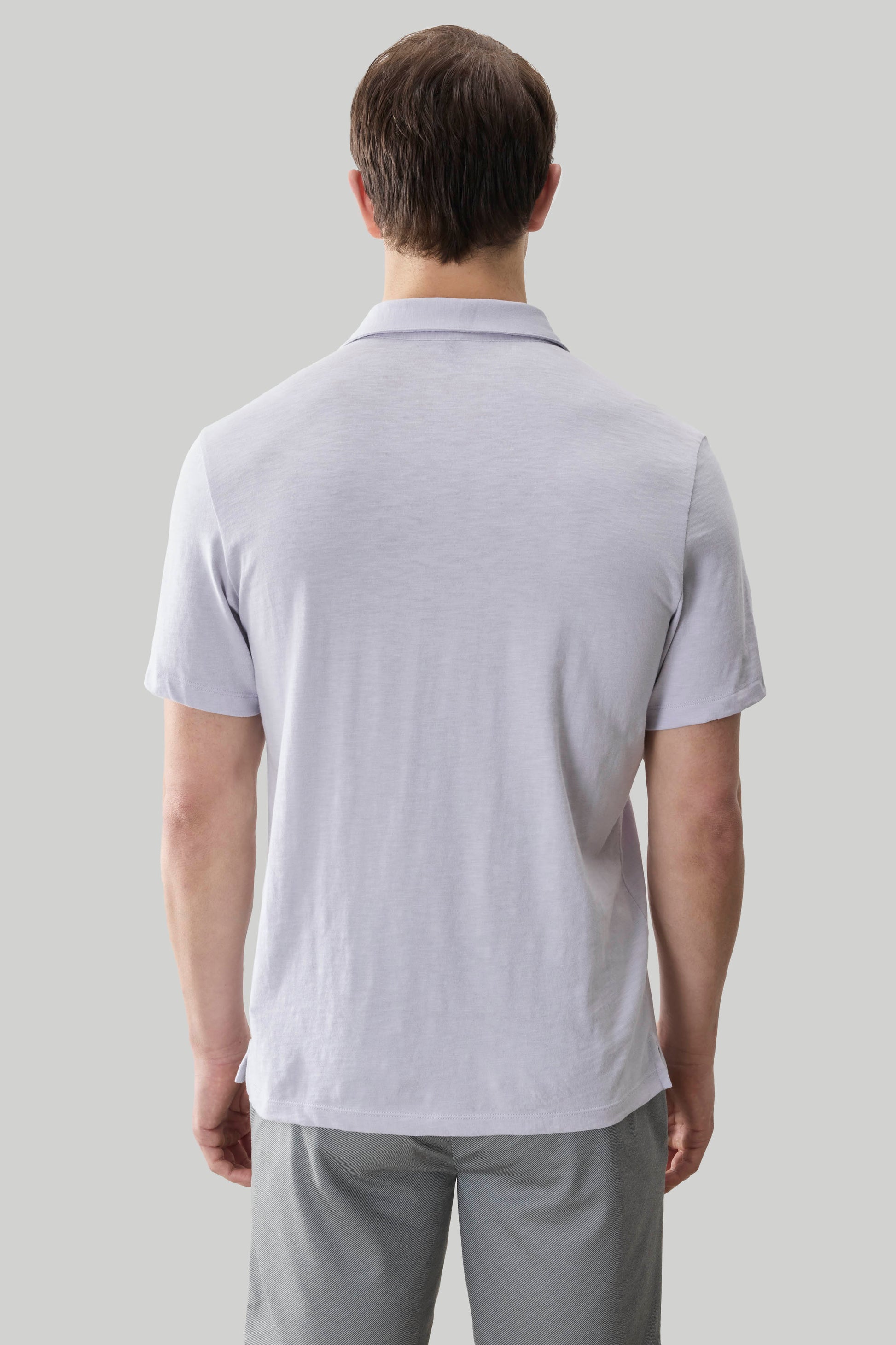 Man wearing light gray short-sleeve polo shirt with collar, shown from back view.