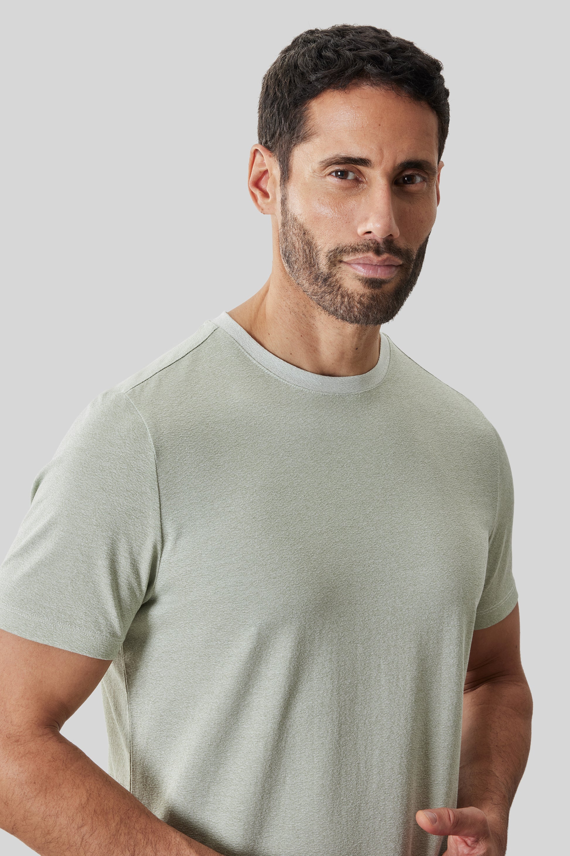 Light sage green short-sleeve crewneck t-shirt with frosted finish, modeled on a man.