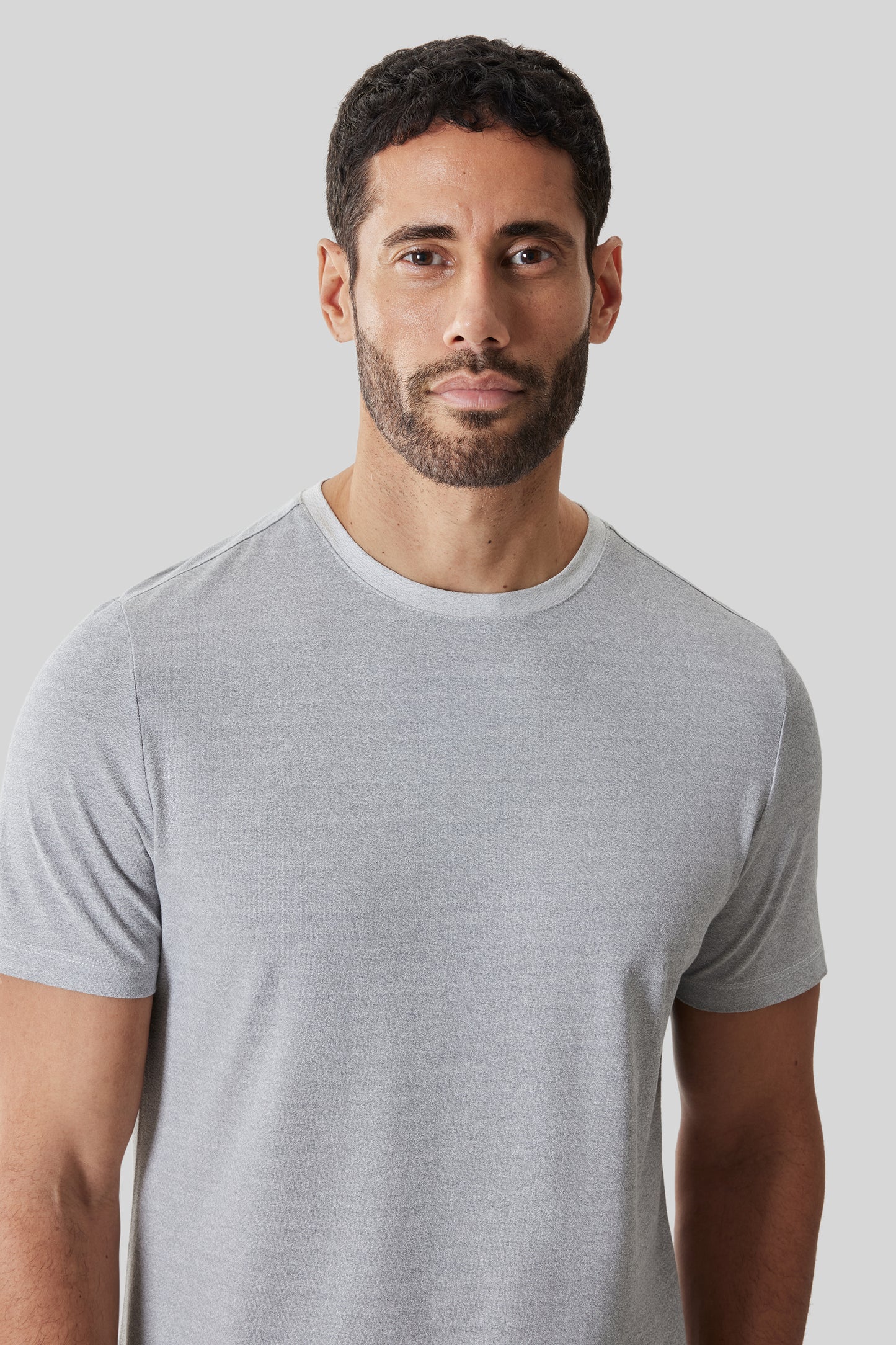 Man wearing a light gray short-sleeve crew neck t-shirt with a relaxed fit.