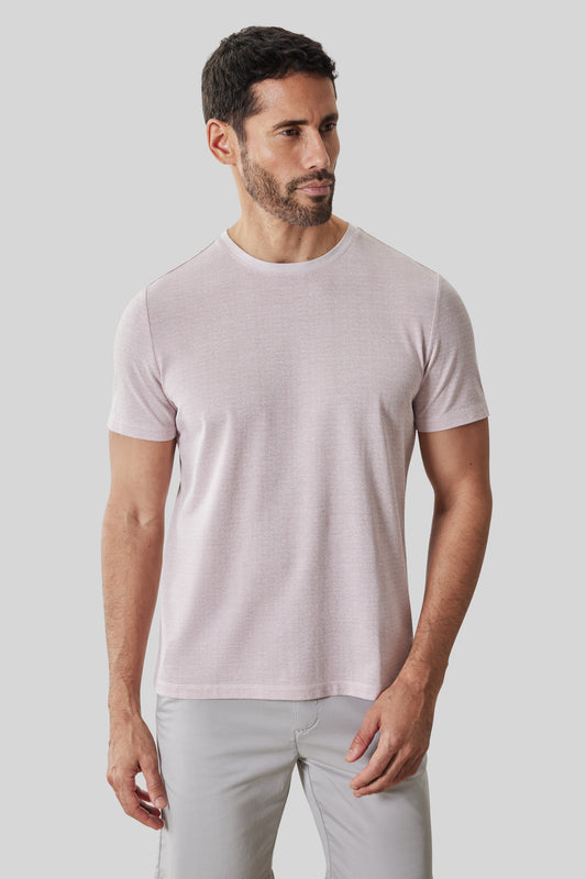 Man wearing light pink short-sleeve crew neck tee with light gray pants.